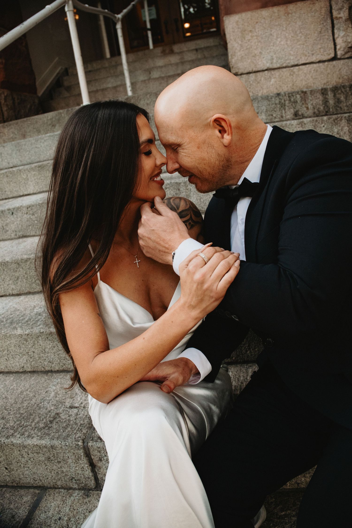 A romantic couple in formal wedding attire share intimate close-up moments in a series of black and white photographs.