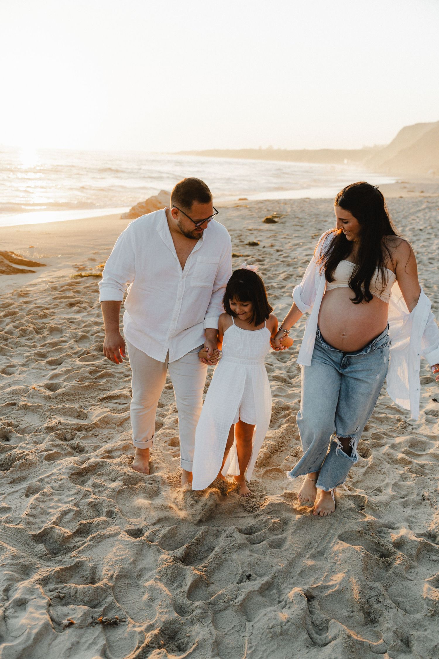 A family enjoying quality time together walking on a sandy beach.