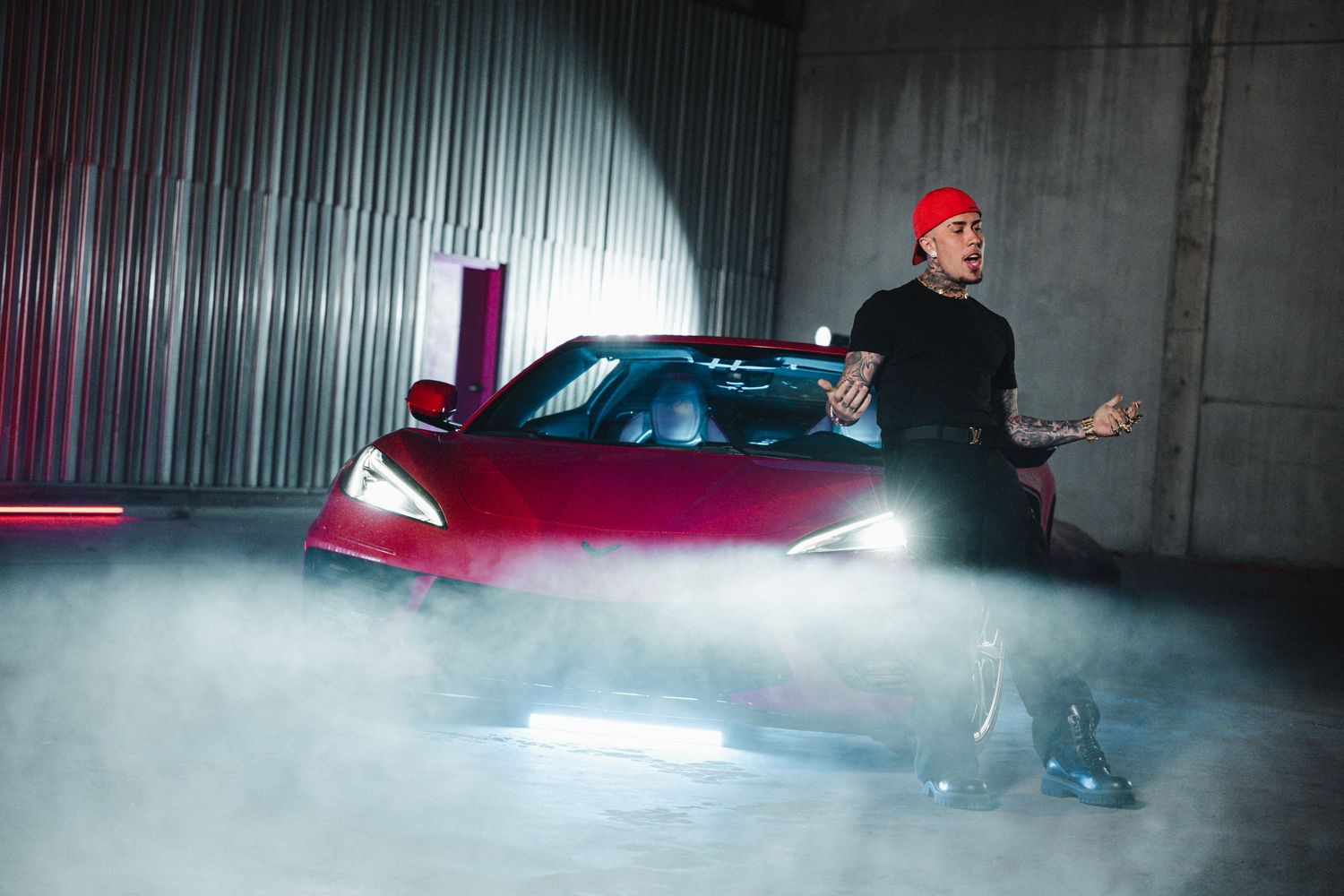 Red sports car photoshoot with dramatic fog effects in industrial space.
