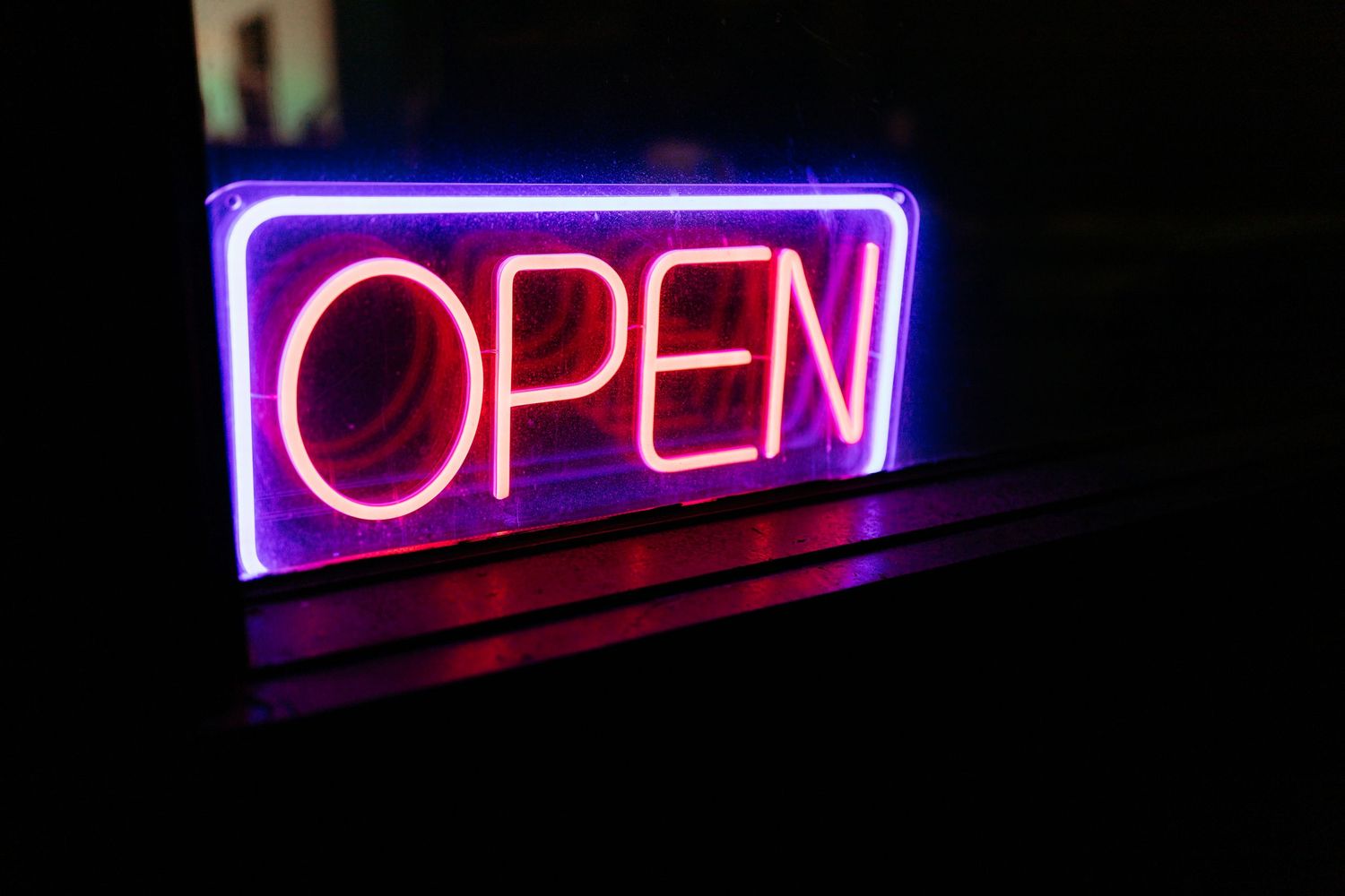Purple neon 'OPEN' sign glowing in the darkness.