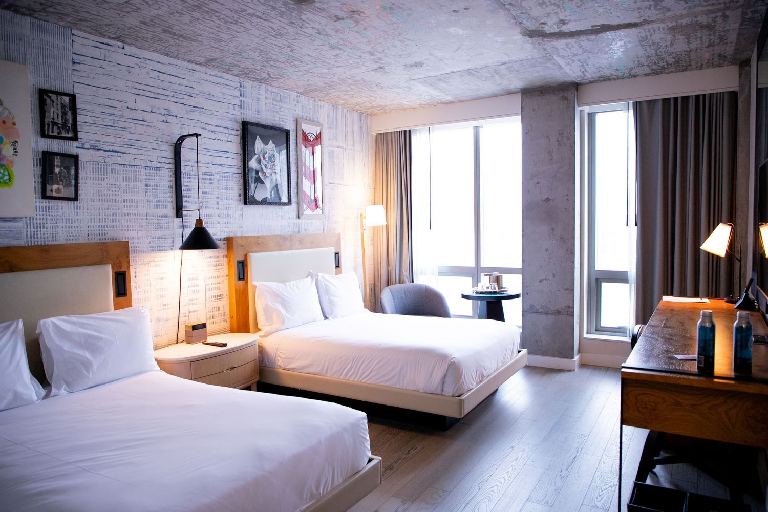 Modern hotel room interior with white brick walls and minimalist furnishings.