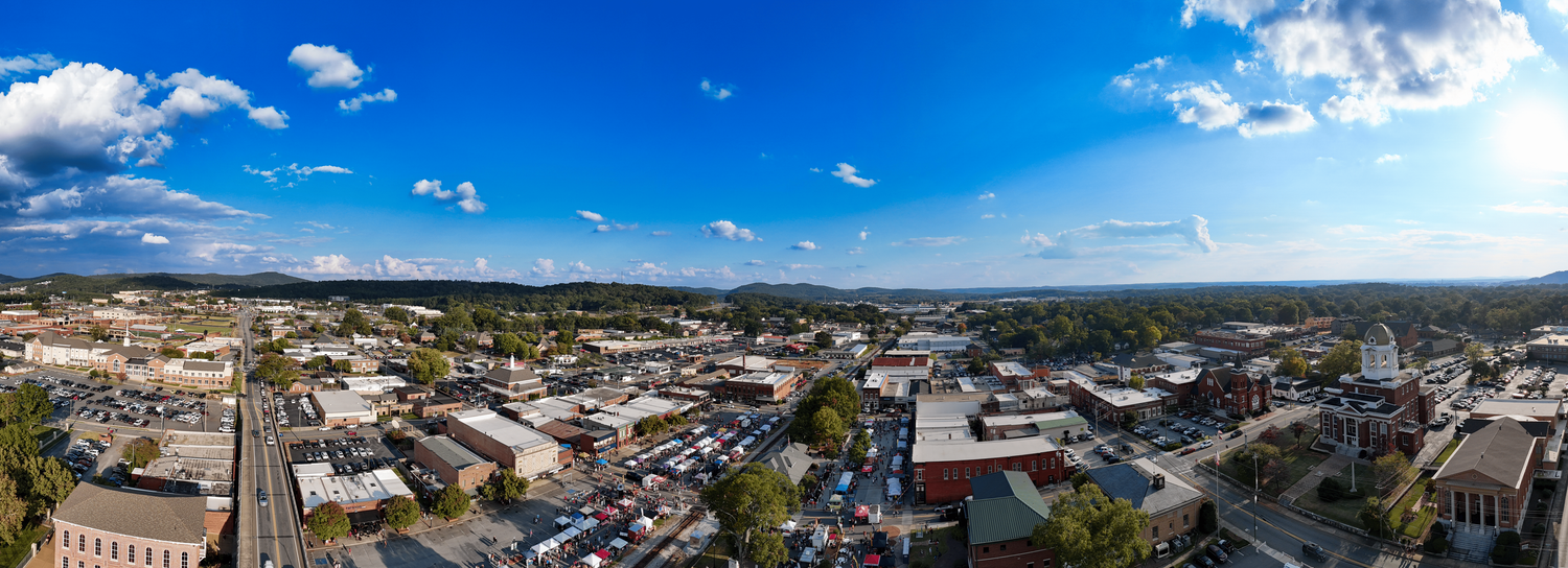 Panoramic aerial view of Cartersville, GA city skyline in with blue sky and white clouds overhead.