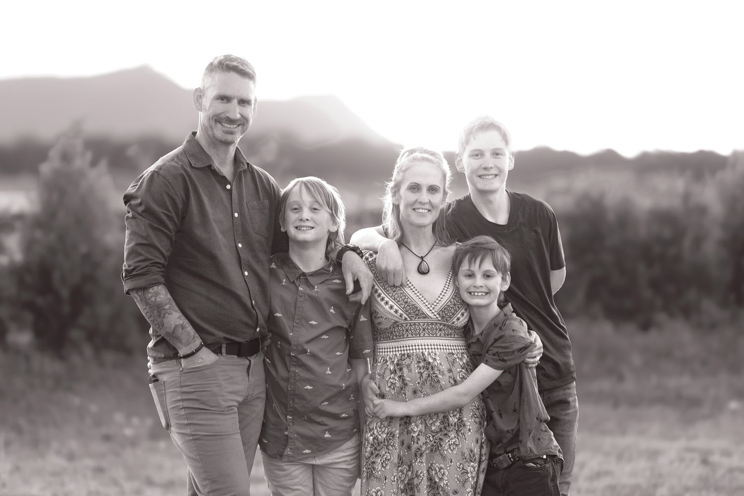 Series of five black and white outdoor family photographs showing laughter and walking together in a natural setting.