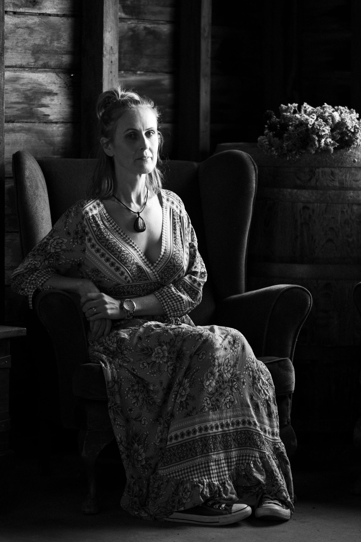 Dramatic black and white portrait in low light interior setting with moody atmosphere.