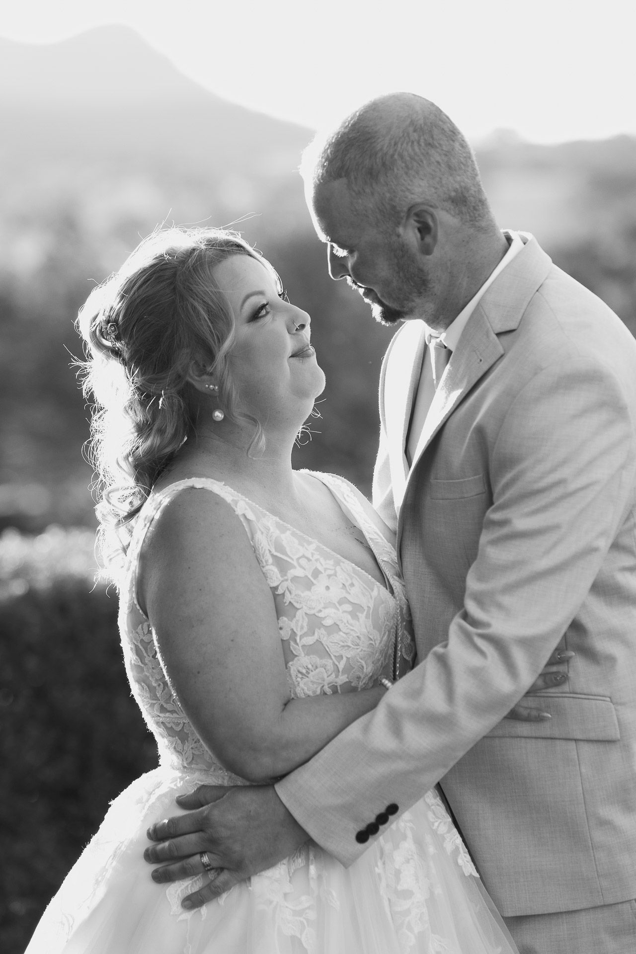 Black and white wedding photos show a romantic sequence of a couple dancing together in an intimate embrace outdoors.