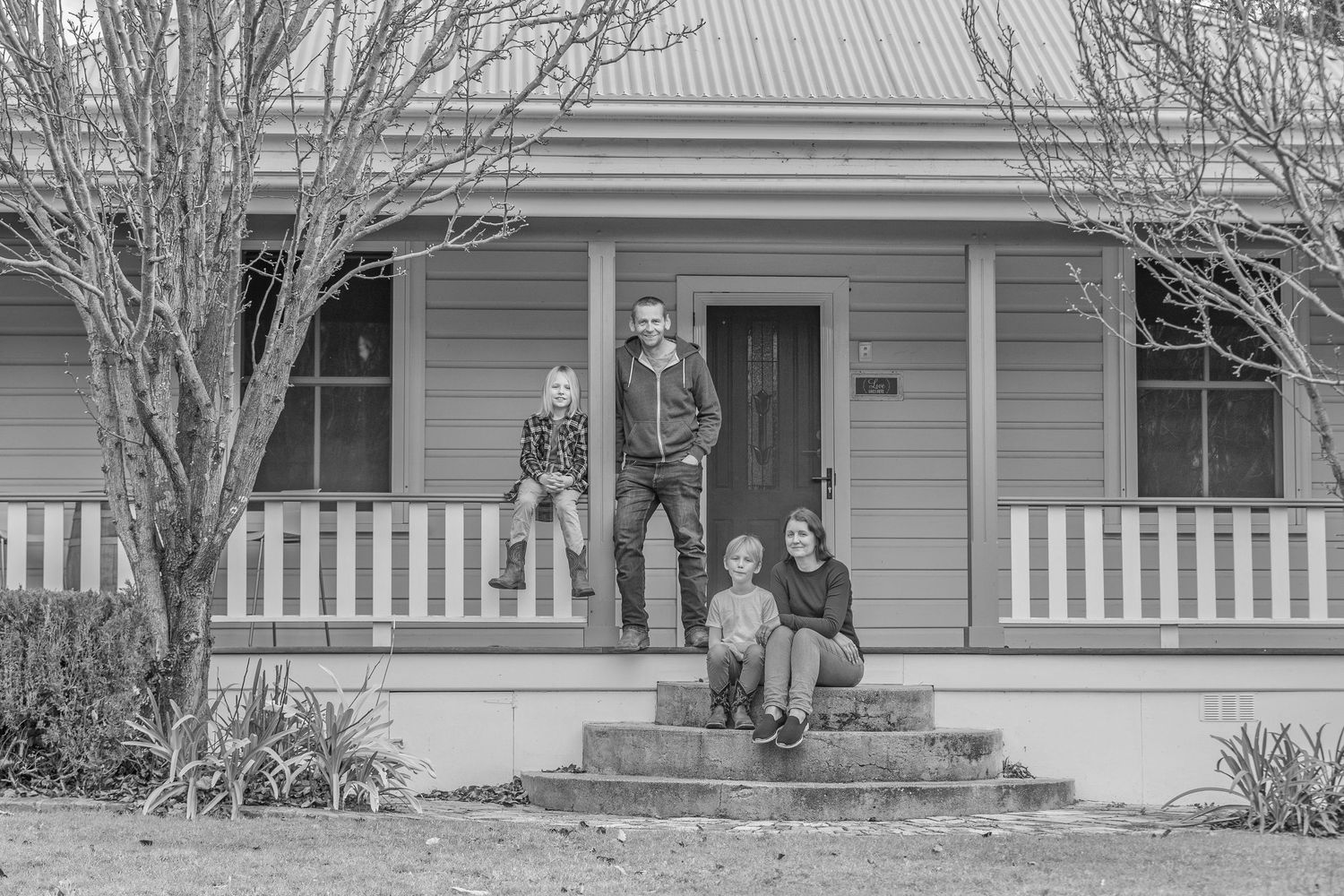 Wide view of gray weatherboard house with white trim and front porch.
