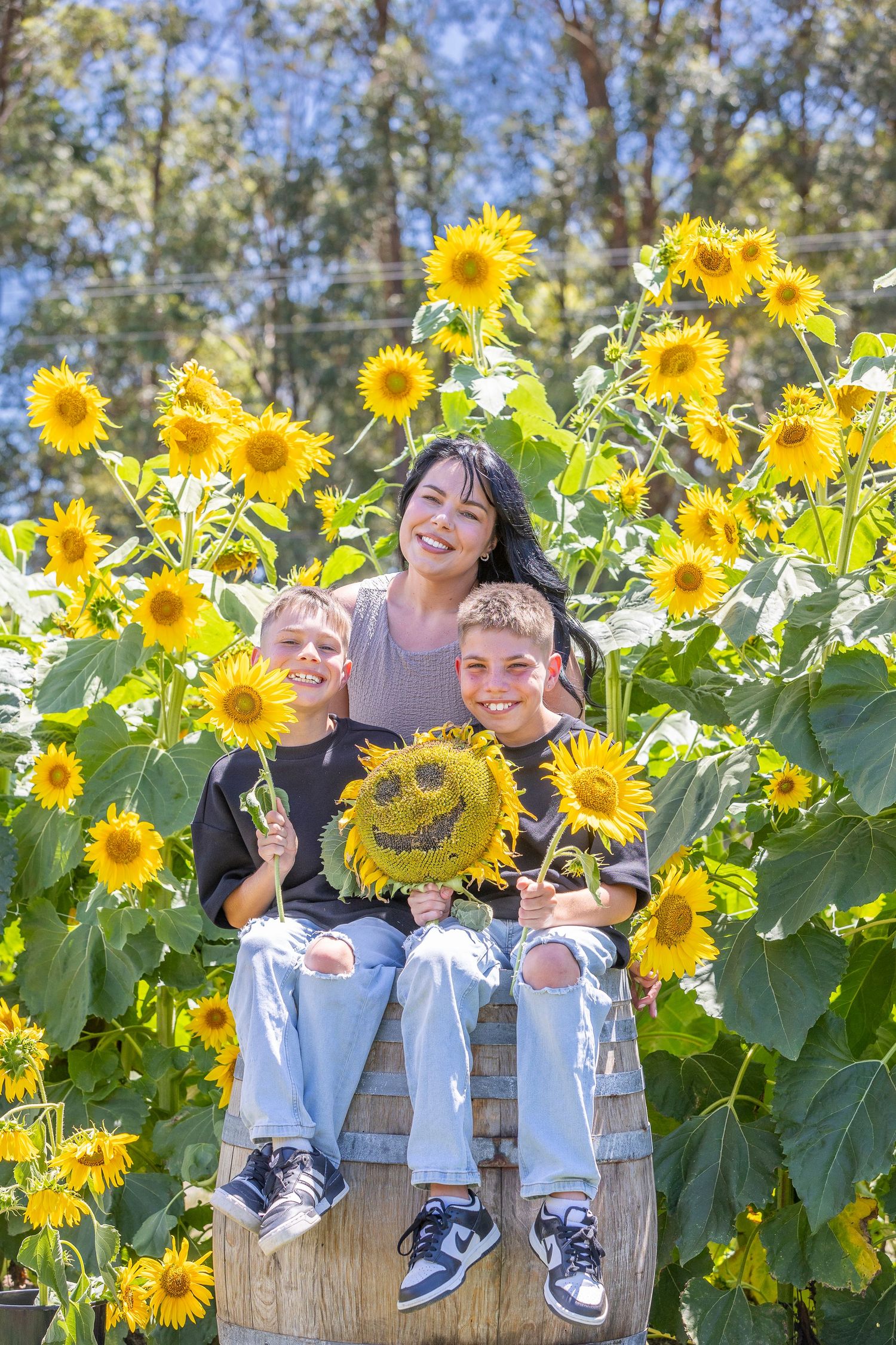 People enjoying a bright summer day in a vibrant sunflower field with tall yellow blooms and green foliage.