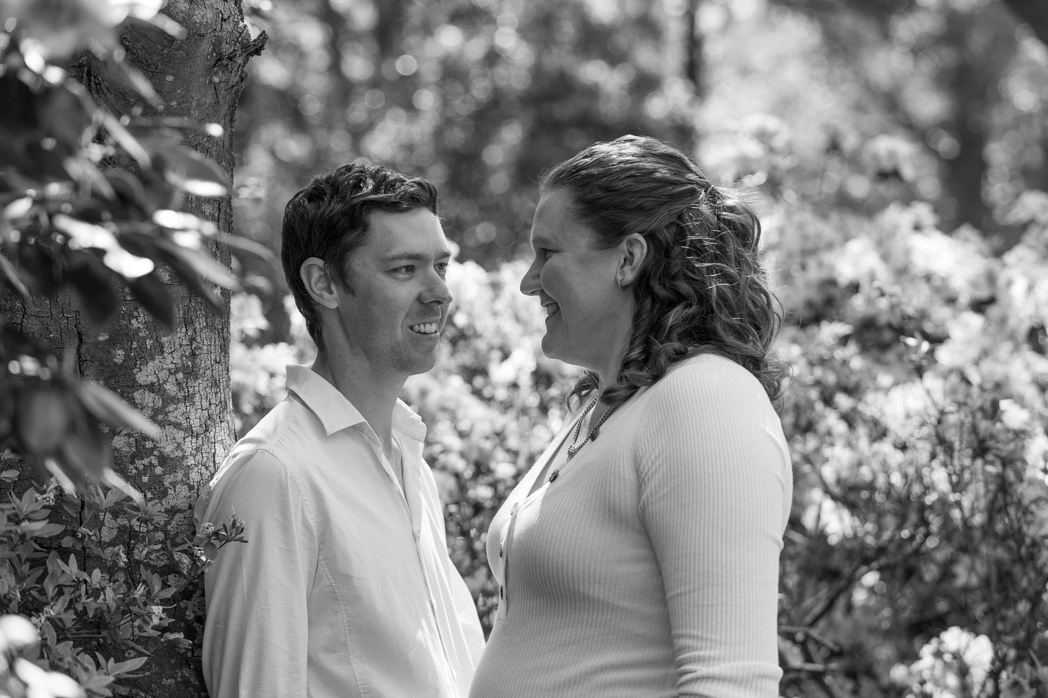 Black and white photo montage showing couple in romantic outdoor wedding moments in garden setting.