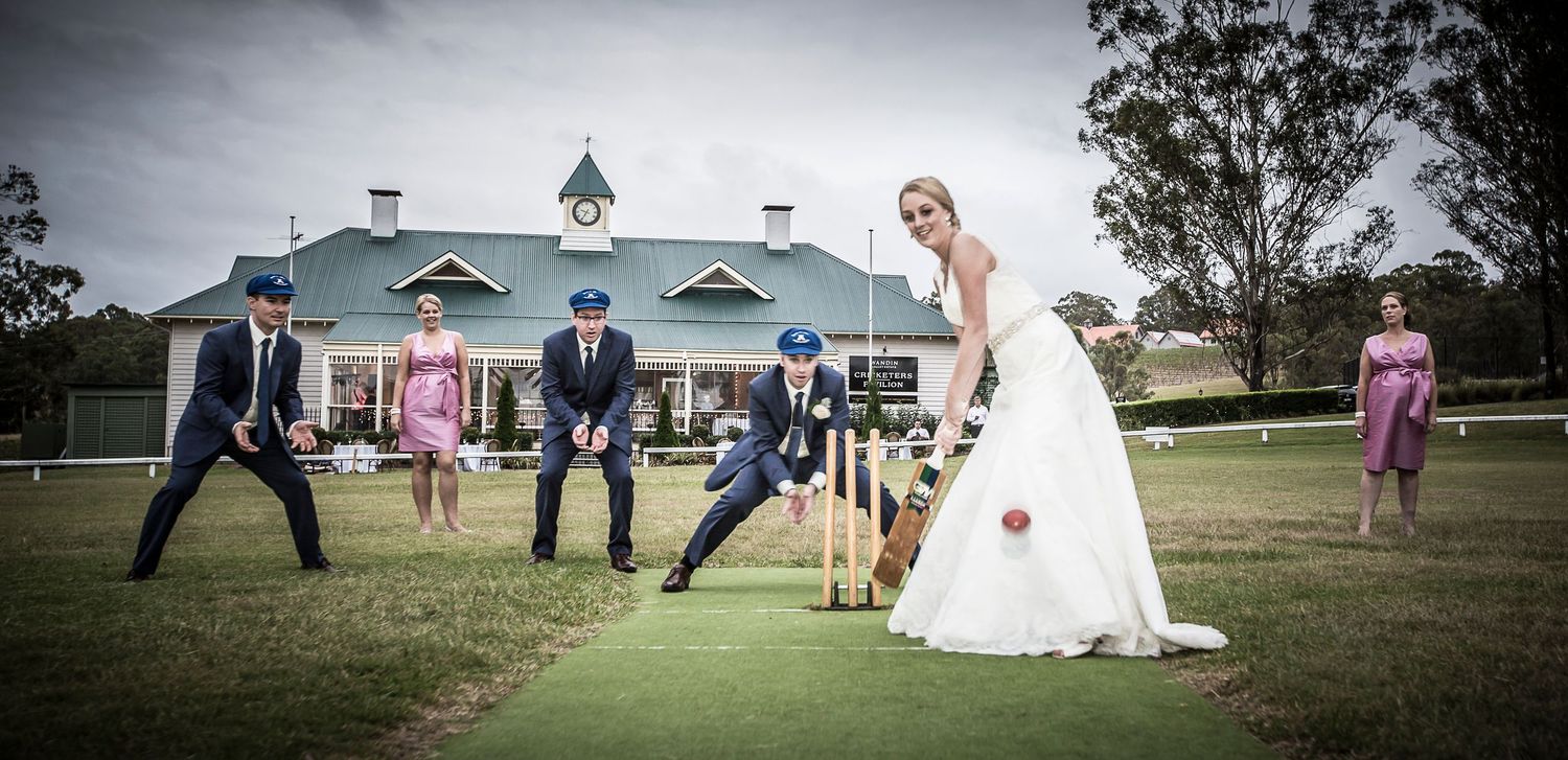 A happy wedding celebration scene in front of cricket stand in the  countryside, the couple playing cricket