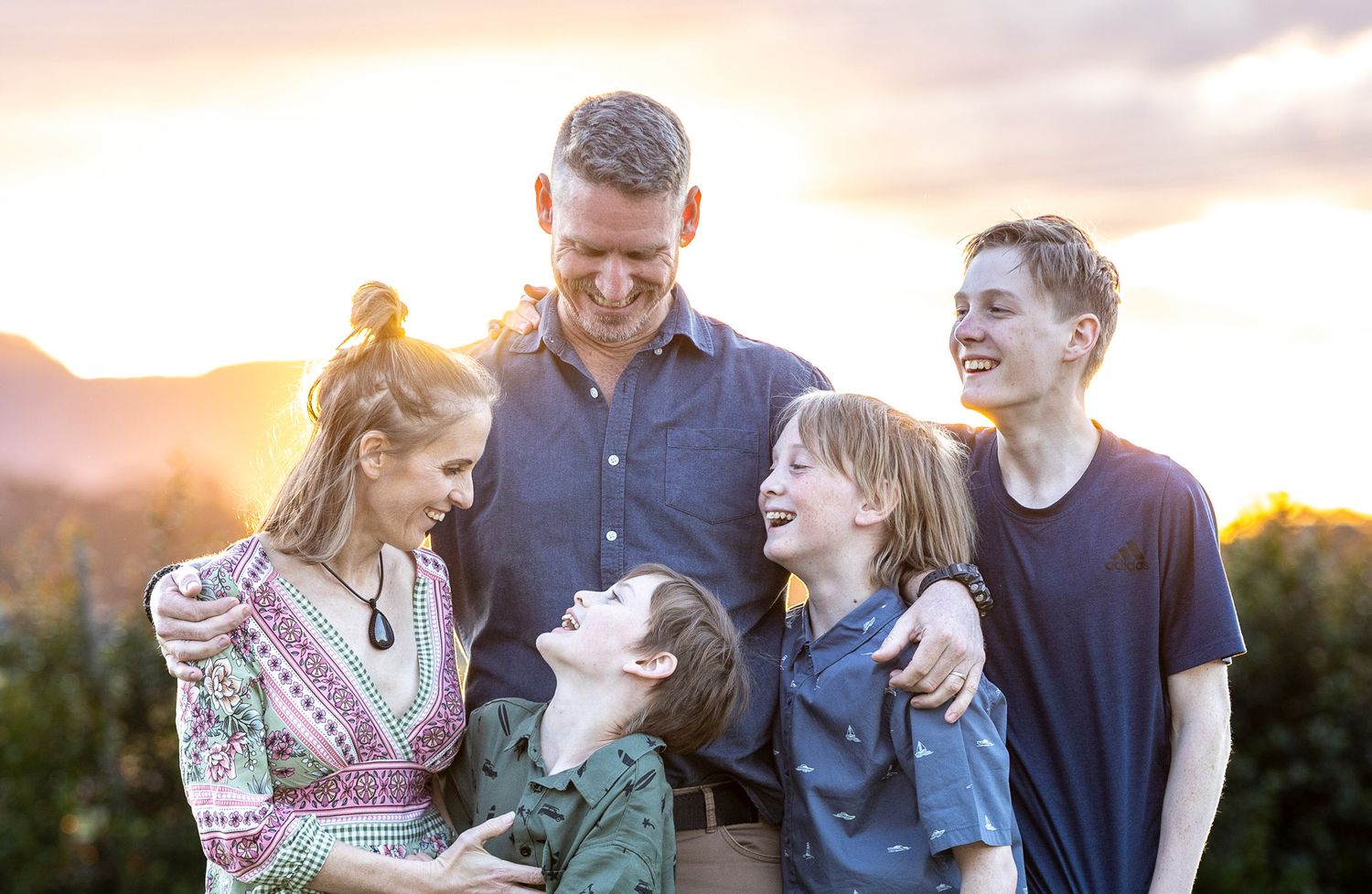 A mosaic of family moments shows people embracing and laughing together outdoors during sunset.