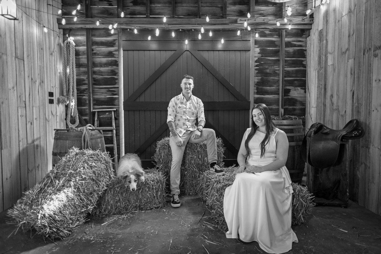 Rustic barn wedding scene with string lights and hay bales creating a cozy atmosphere.