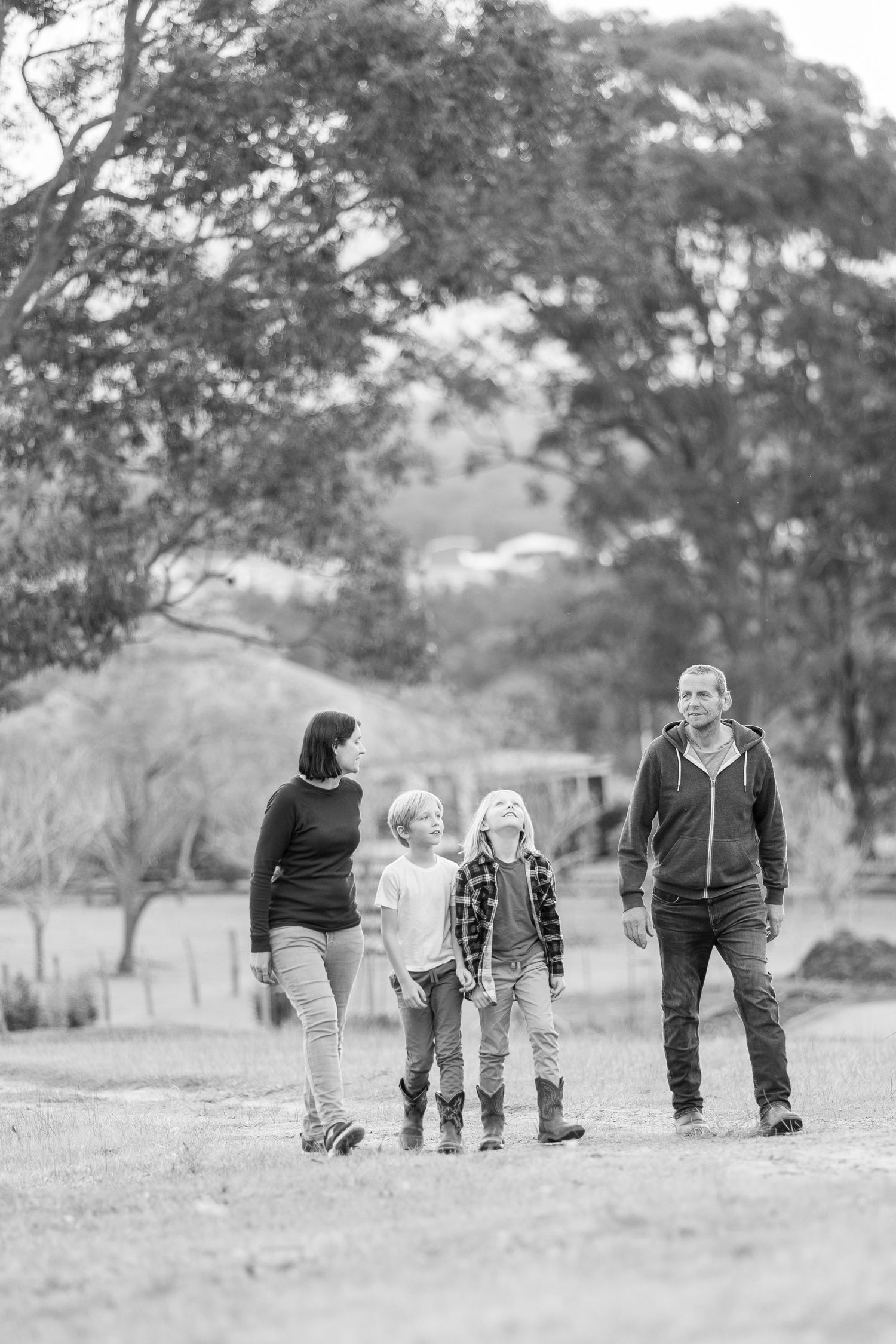 A family takes a casual stroll together through a peaceful countryside setting.