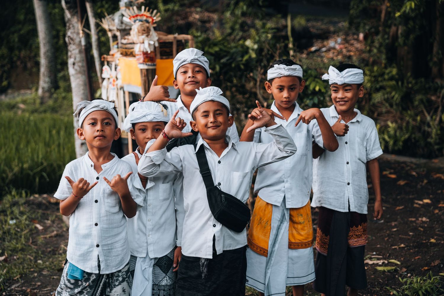 Students in white uniforms gather outdoors for a group activity.
