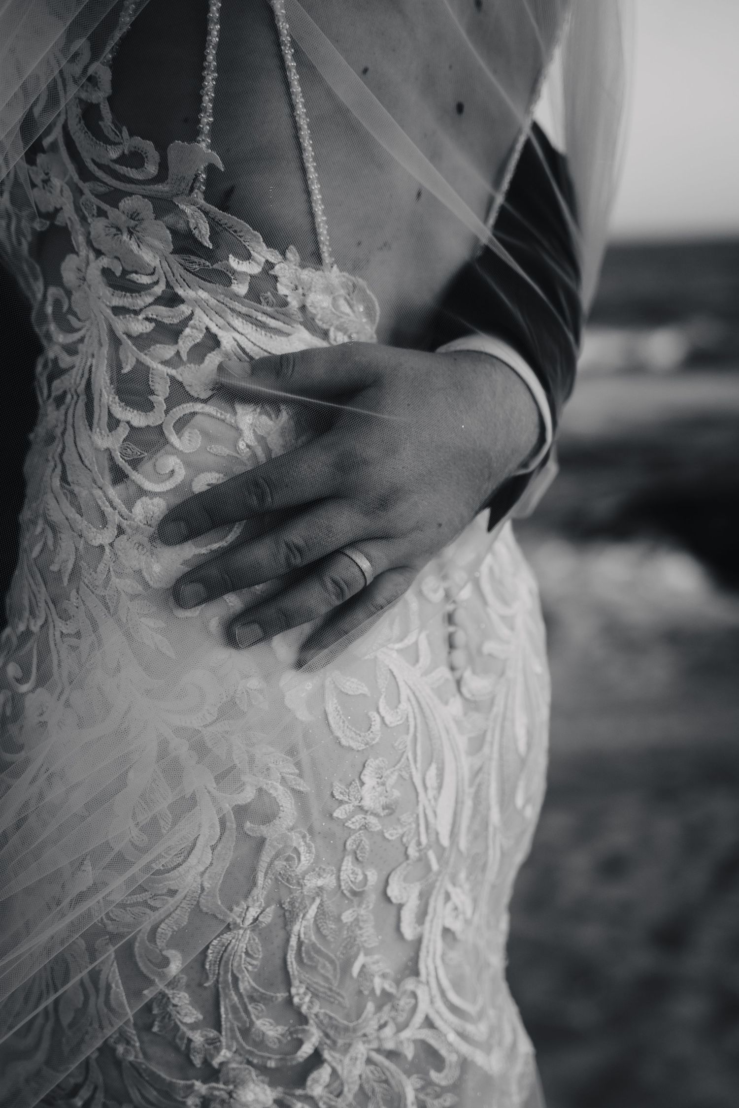 Close-up detail of intricate lace pattern on wedding dress.