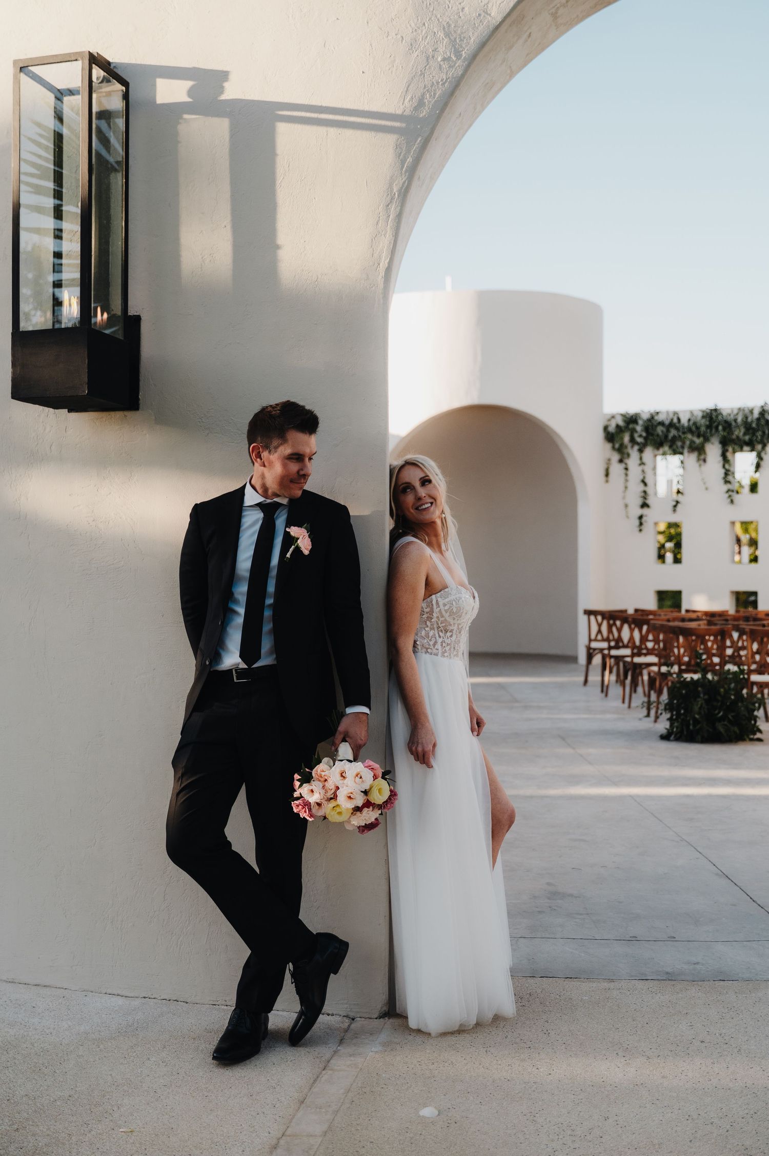 Elegant wedding photography in a white archway venue with architectural details.