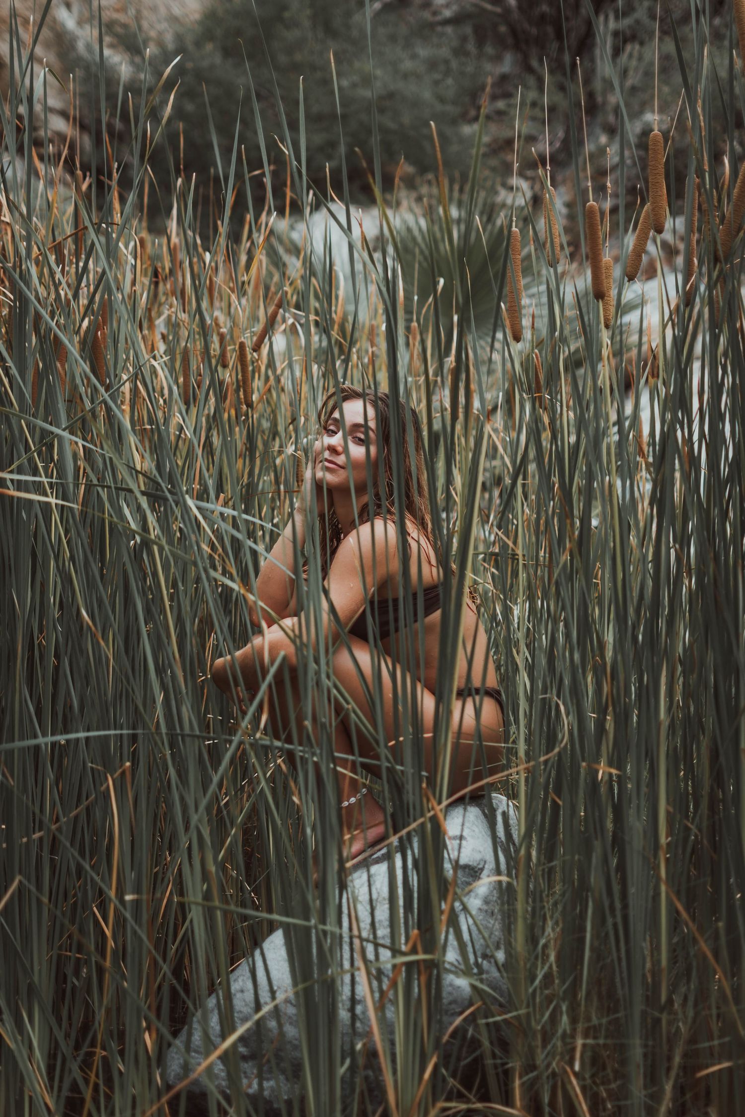 Artistic portrait among tall marsh reeds in natural lighting.