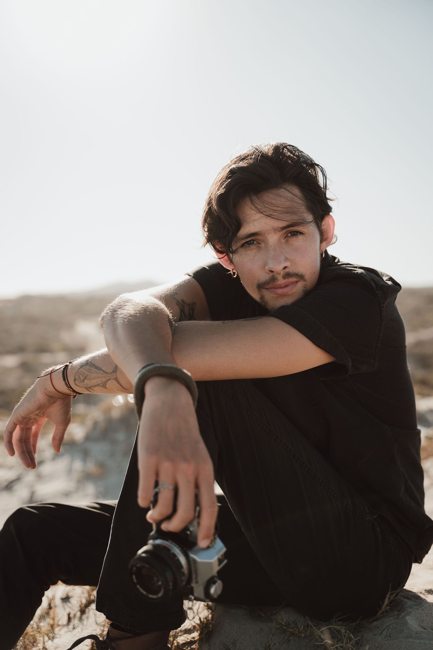 Artistic portrait session on sand dunes with natural lighting and desert landscape.