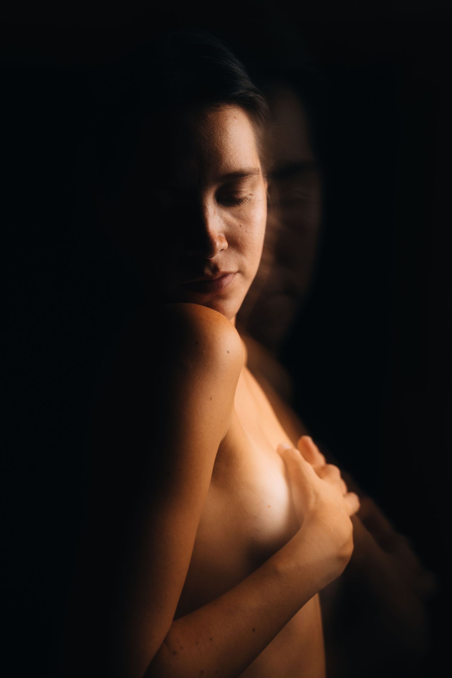 Artistic portrait with dramatic side lighting creating shadow patterns.