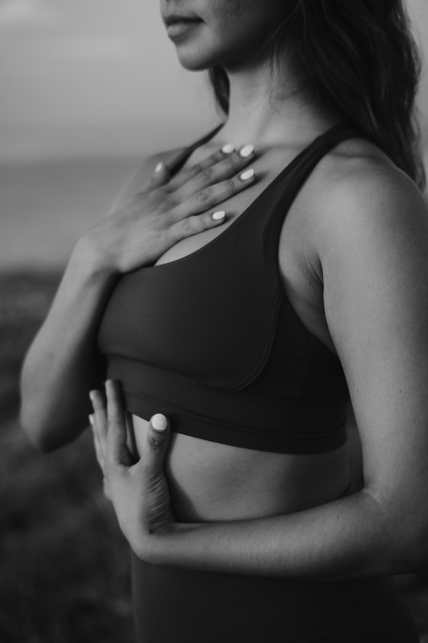 Close-up profile shot of person in black sports bra against dark background.