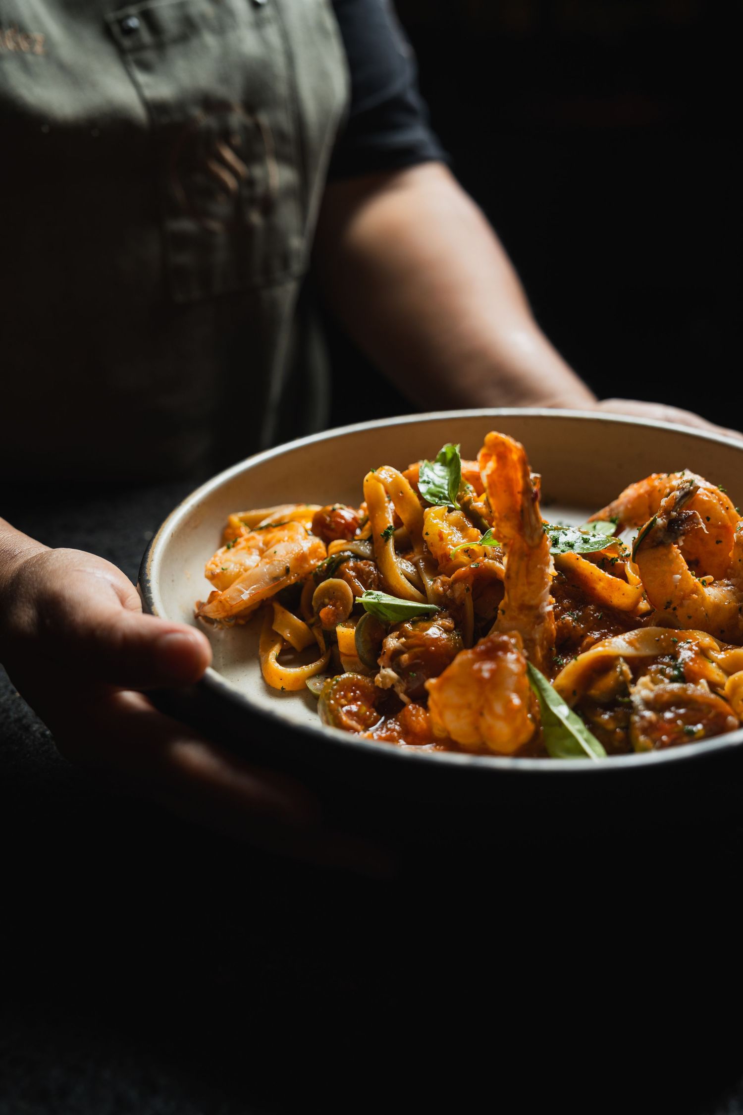 Sautéed mushrooms with herbs in dramatic lighting on white ceramic plate.