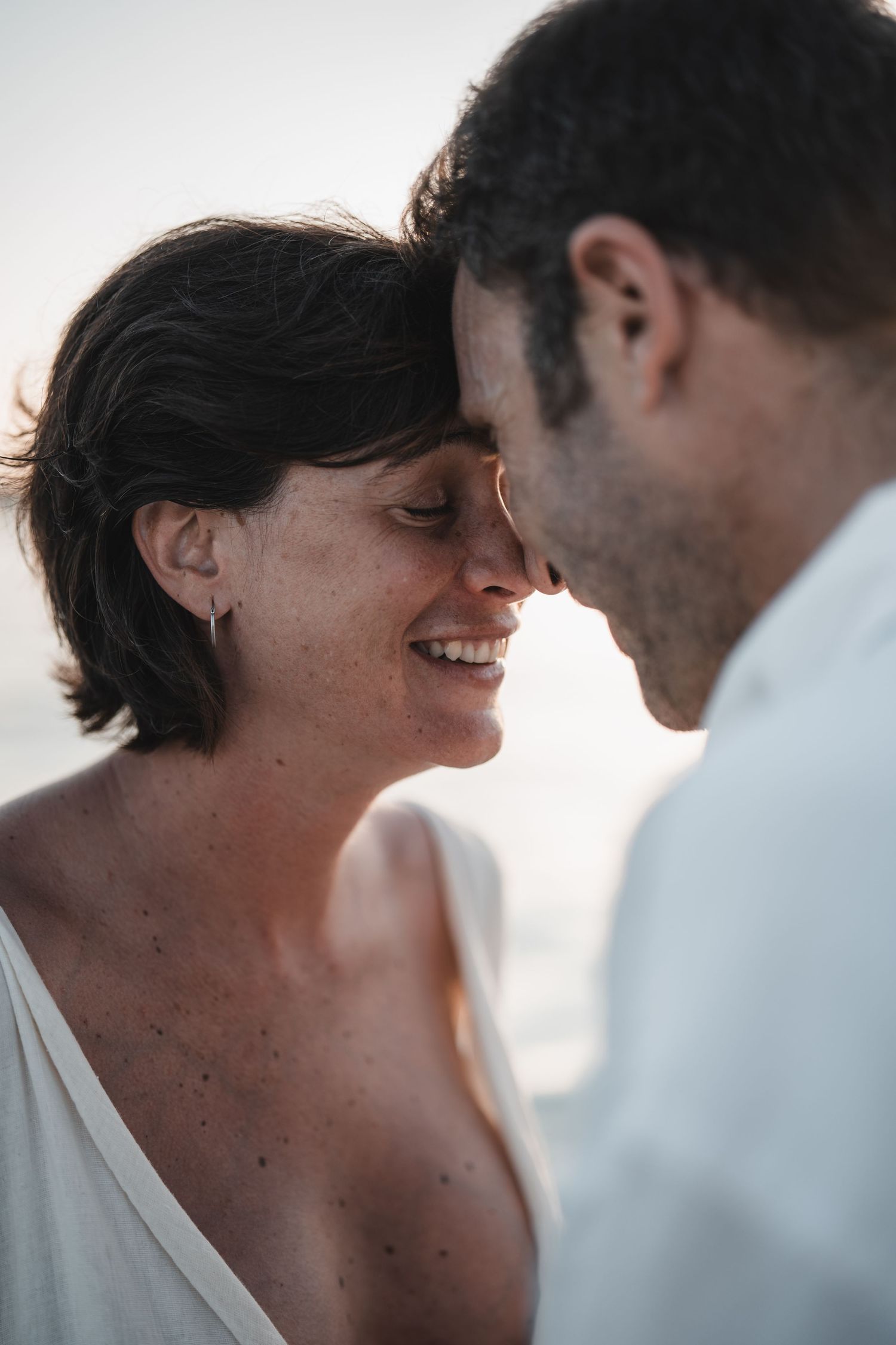 Intimate romantic moment silhouetted against soft natural lighting.