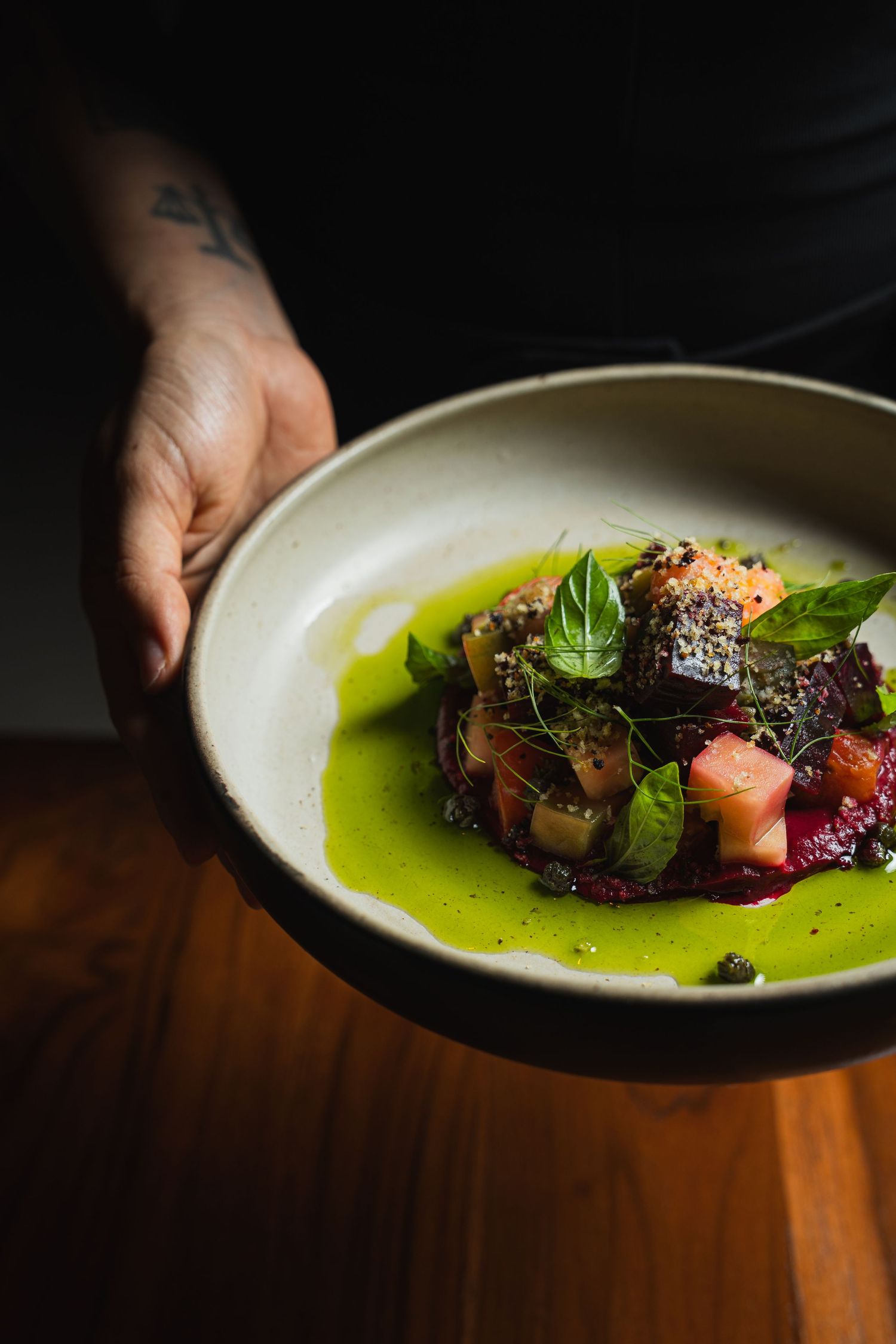 Artistically plated dish with microgreens and sauce on white ceramic plate.