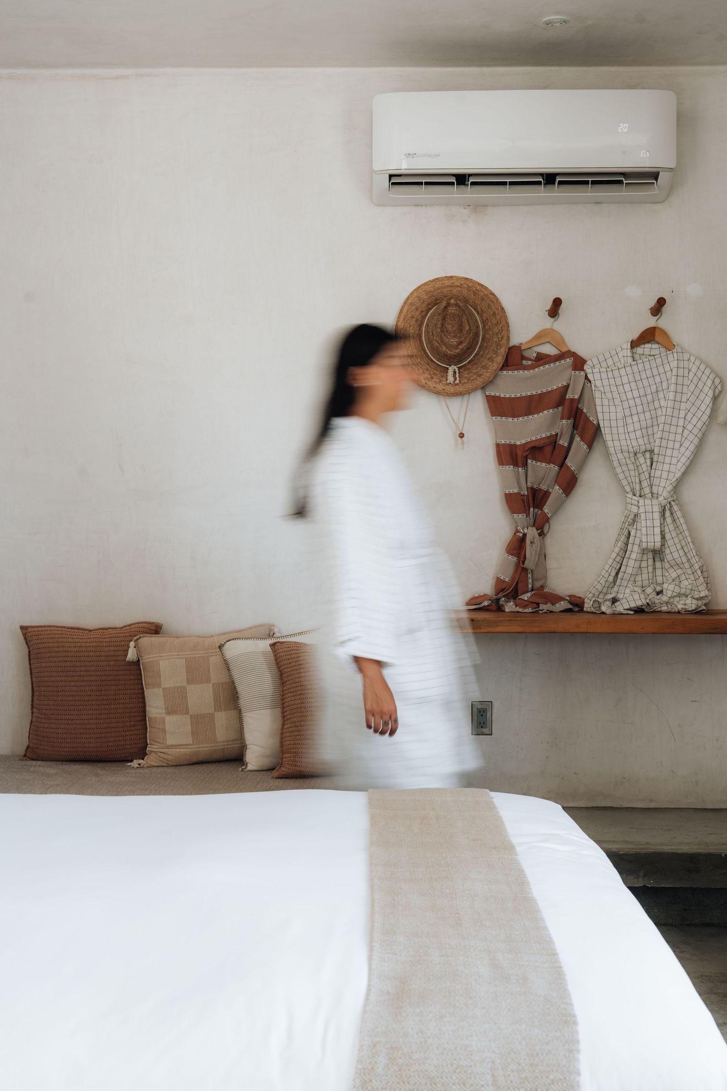 Interior scene showing movement across a white room with decorative dress forms on the wall.