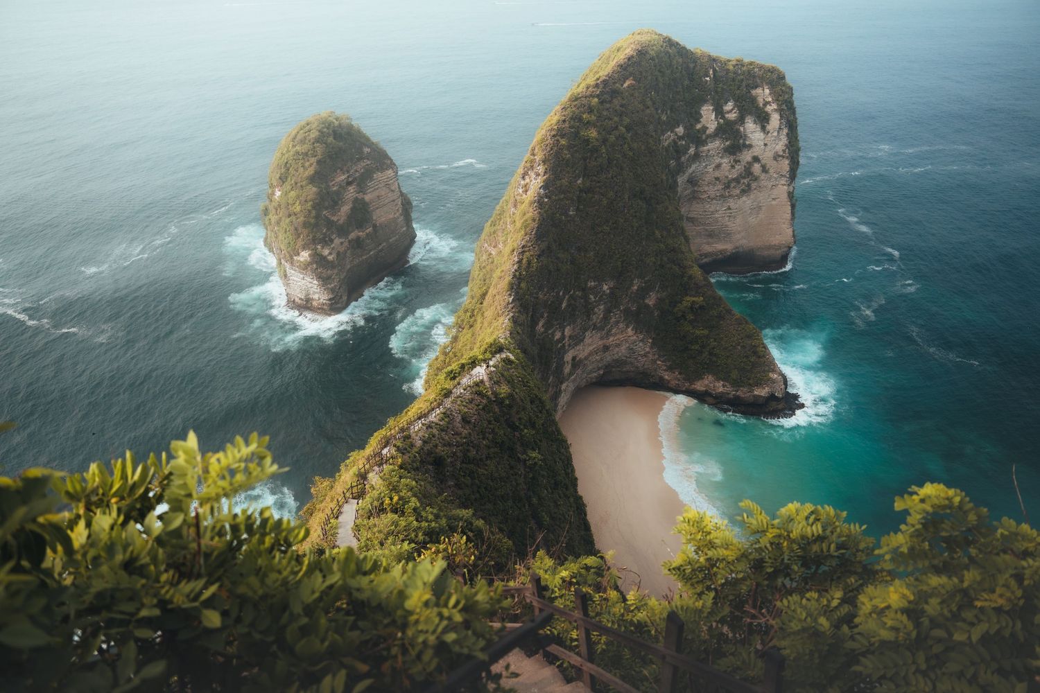 Majestic coastal cliffs overlooking a hidden beach cove with emerald waters.
