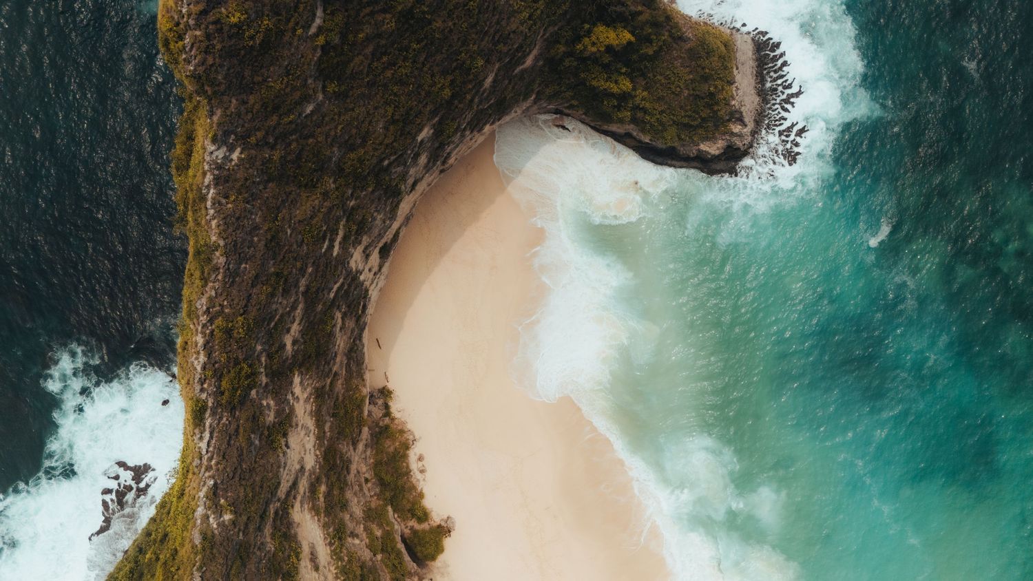 Dramatic coastal cliff formations with waves crashing against rocky shores.