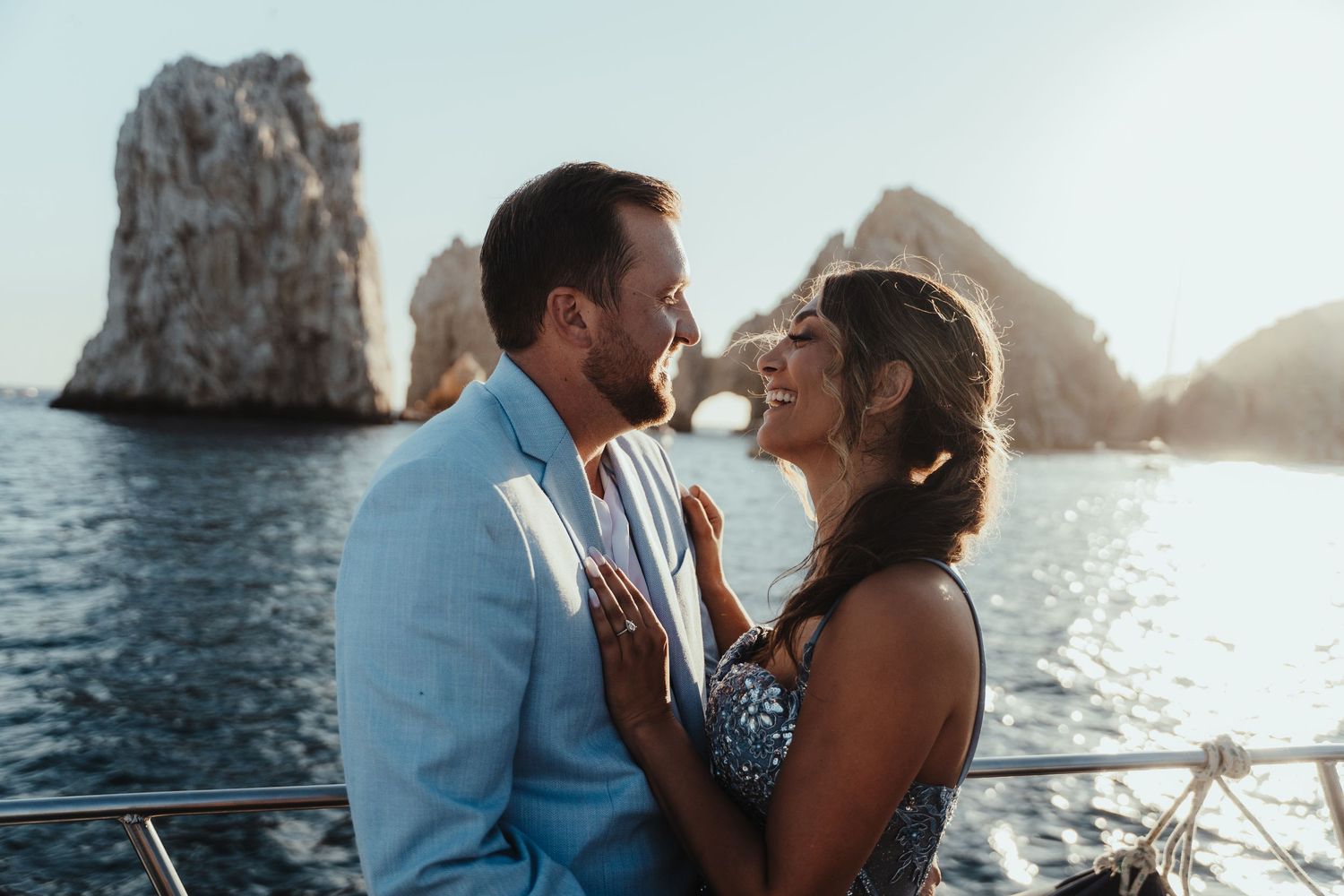 Romantic boat ride along rocky coastal cliffs at sunset.