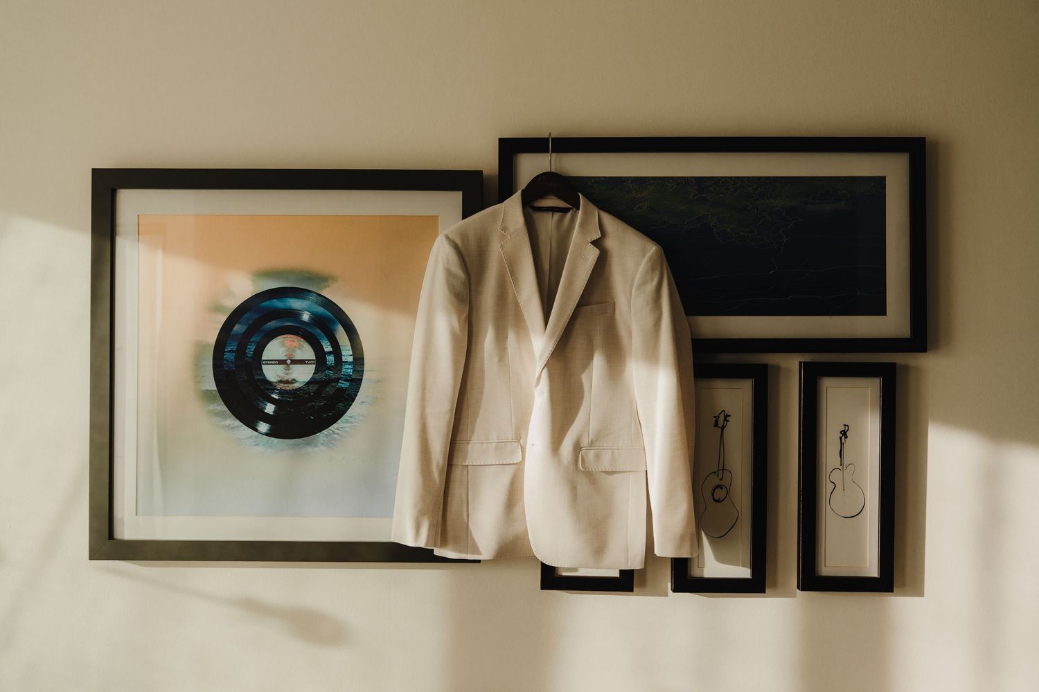 Wedding attire and formal wear displayed on hangers in preparation room.