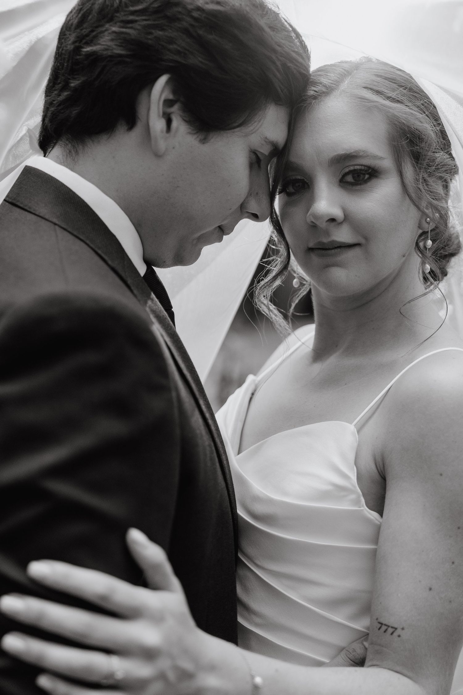 Intimate black and white portrait of tender wedding moment.