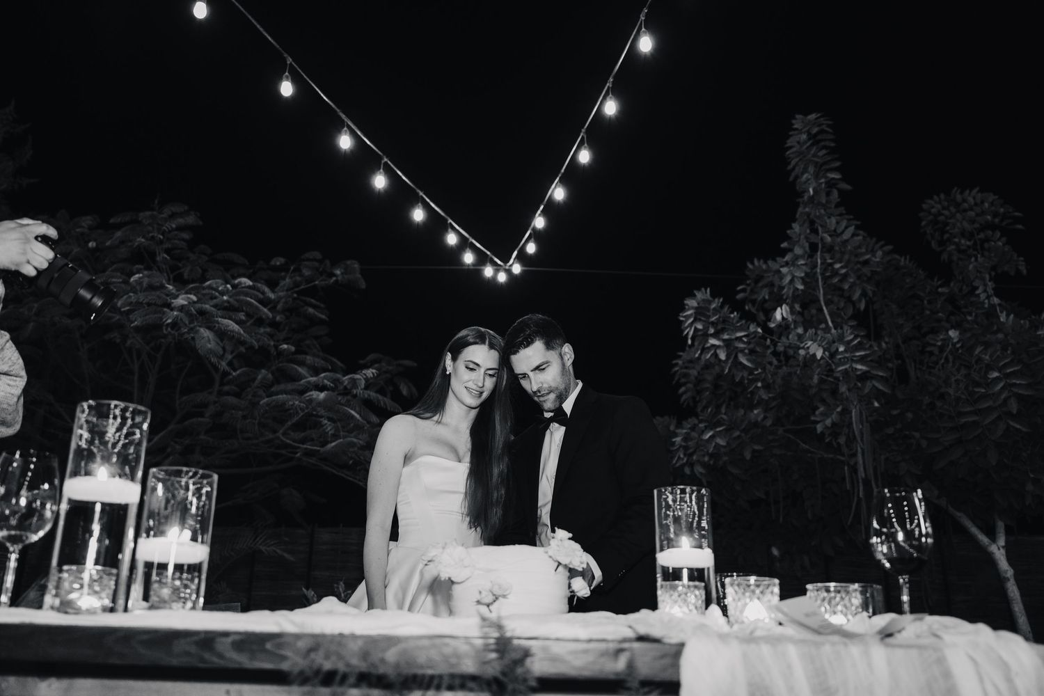 Romantic wedding reception under twinkling string lights at night.