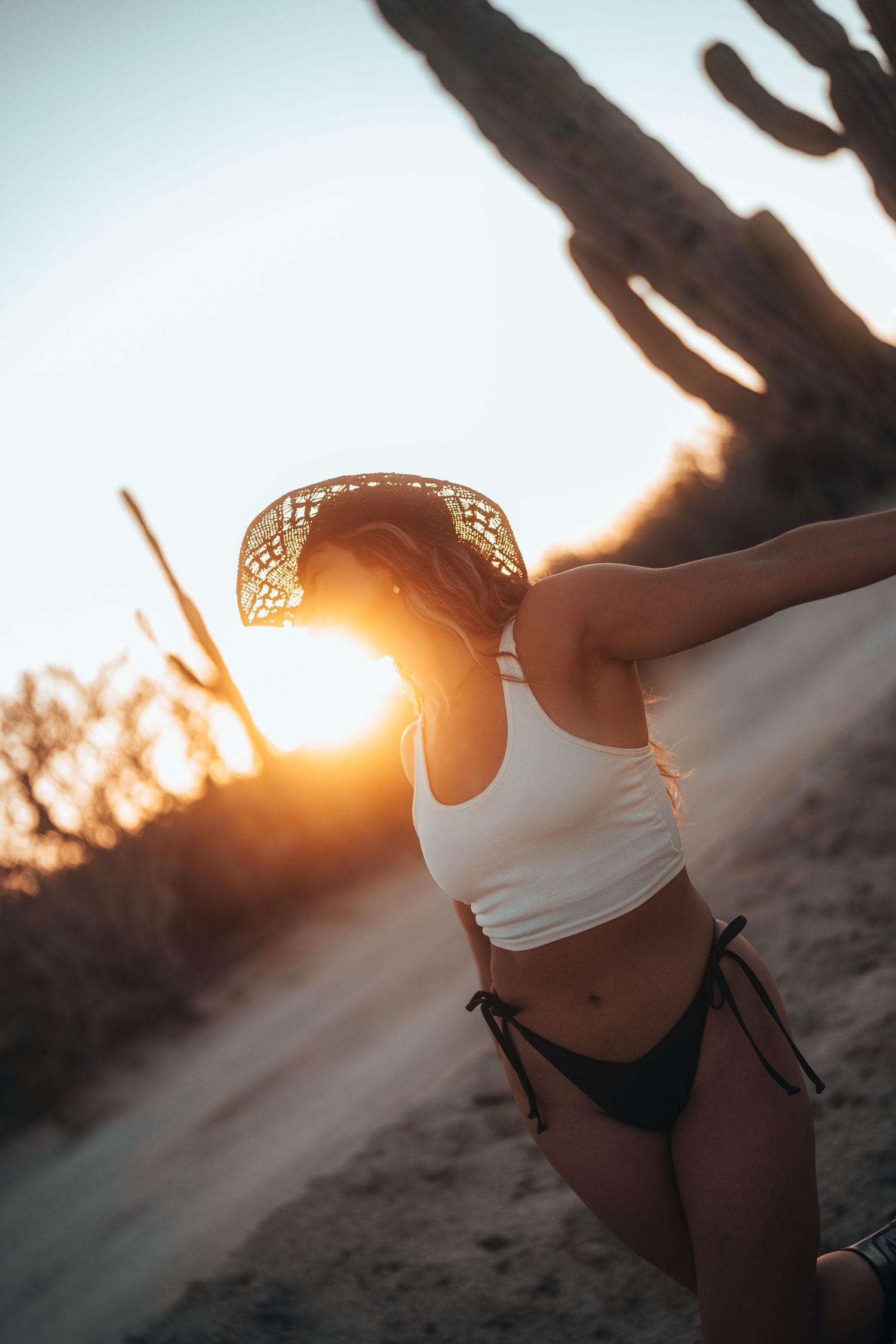 Artistic swimwear photography with golden sunset backlighting.