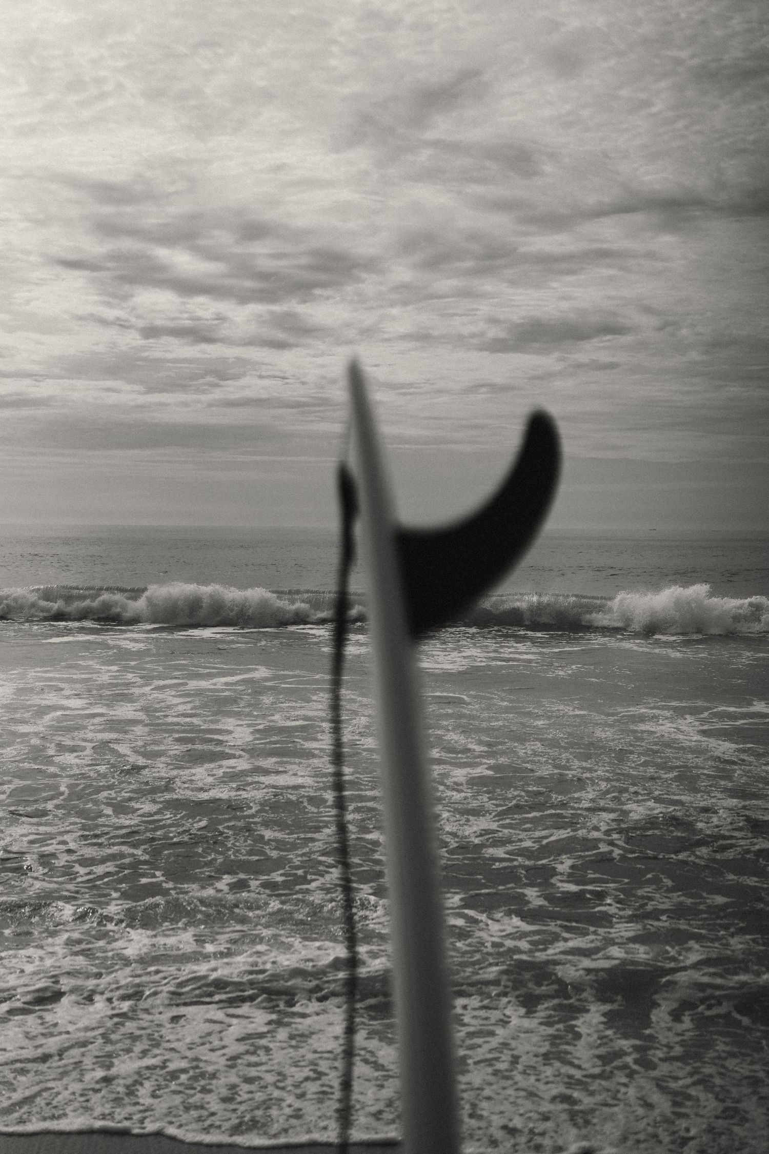 Black and white seascape showing ocean waves and surf from elevated perspective.