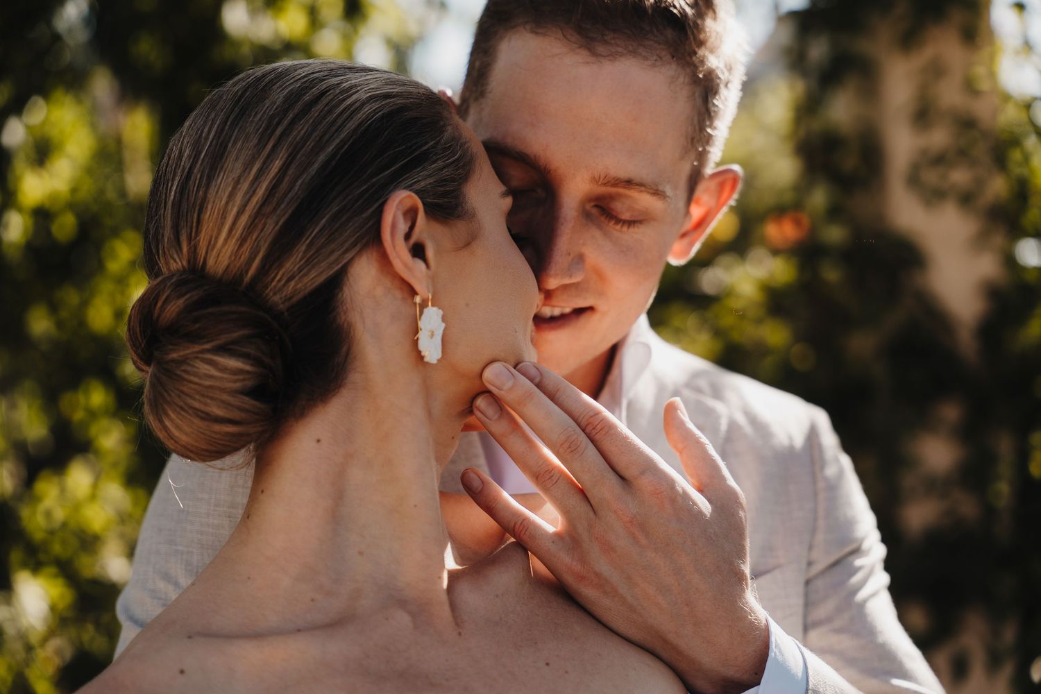 Romantic couple shares tender outdoor moment in golden sunlight.