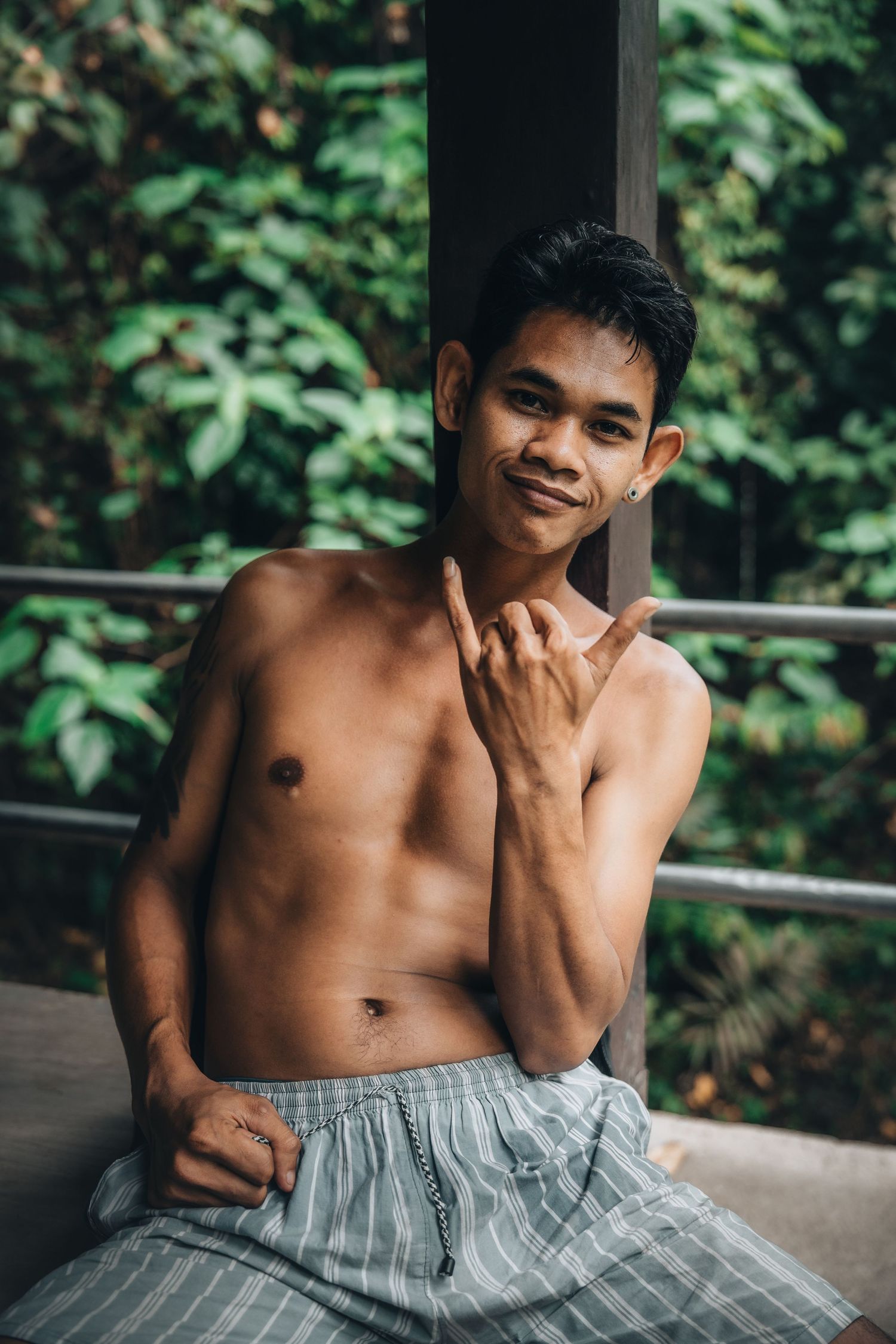 Portrait set showing shirtless figure in multiple candid expressions against a blurred green background.