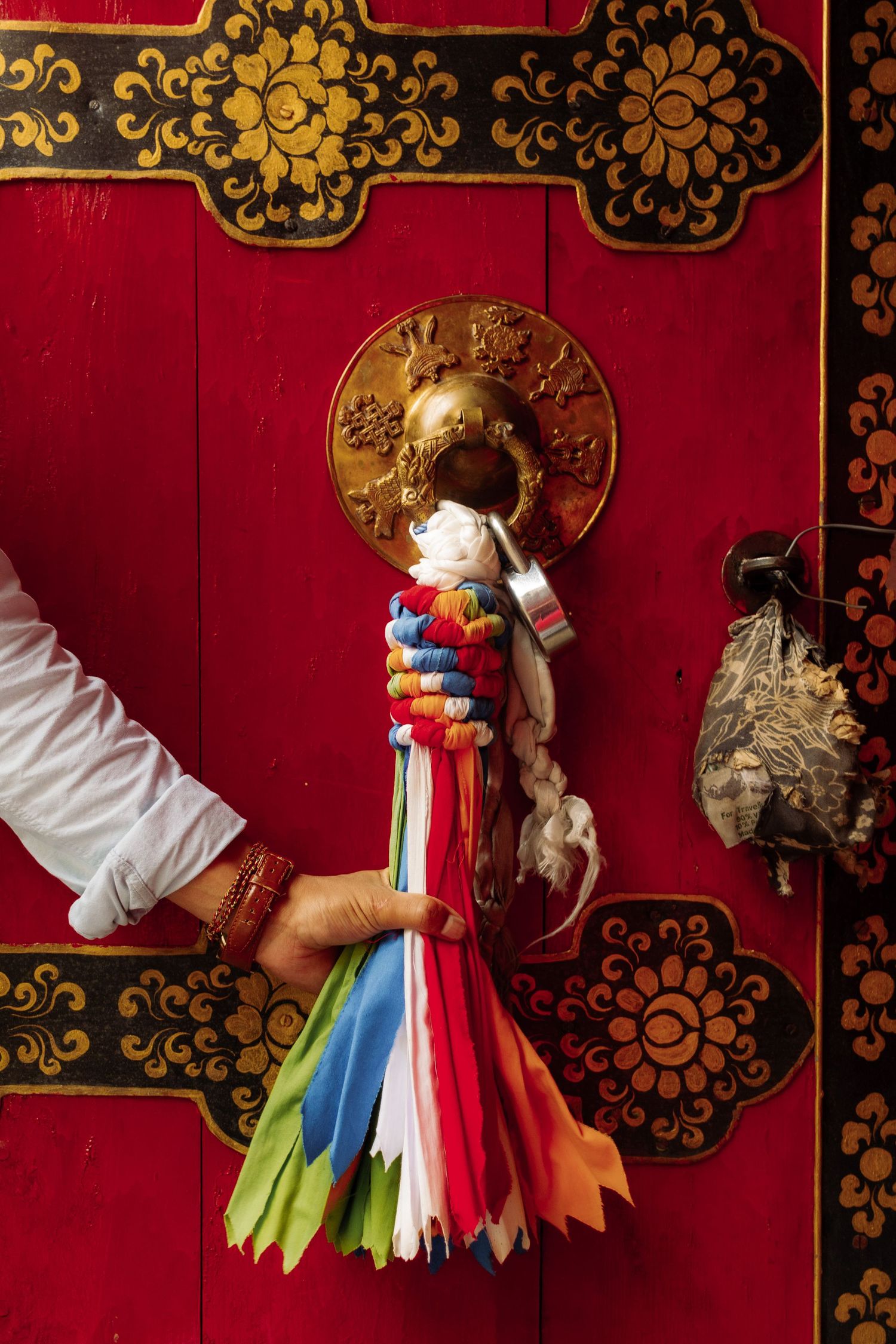 A man holds a decoration on the door of a temple in Dharamsala, India