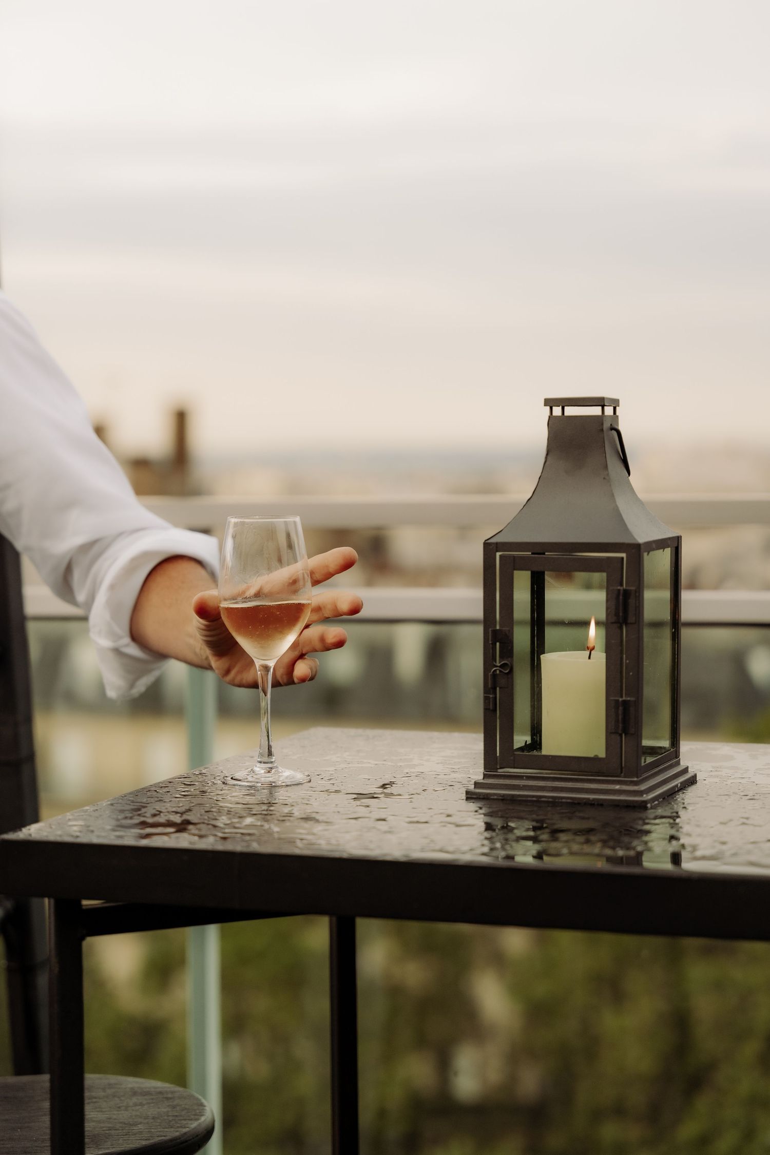A man takes a glass of champagne on a table on the rooftop of a building in Paris