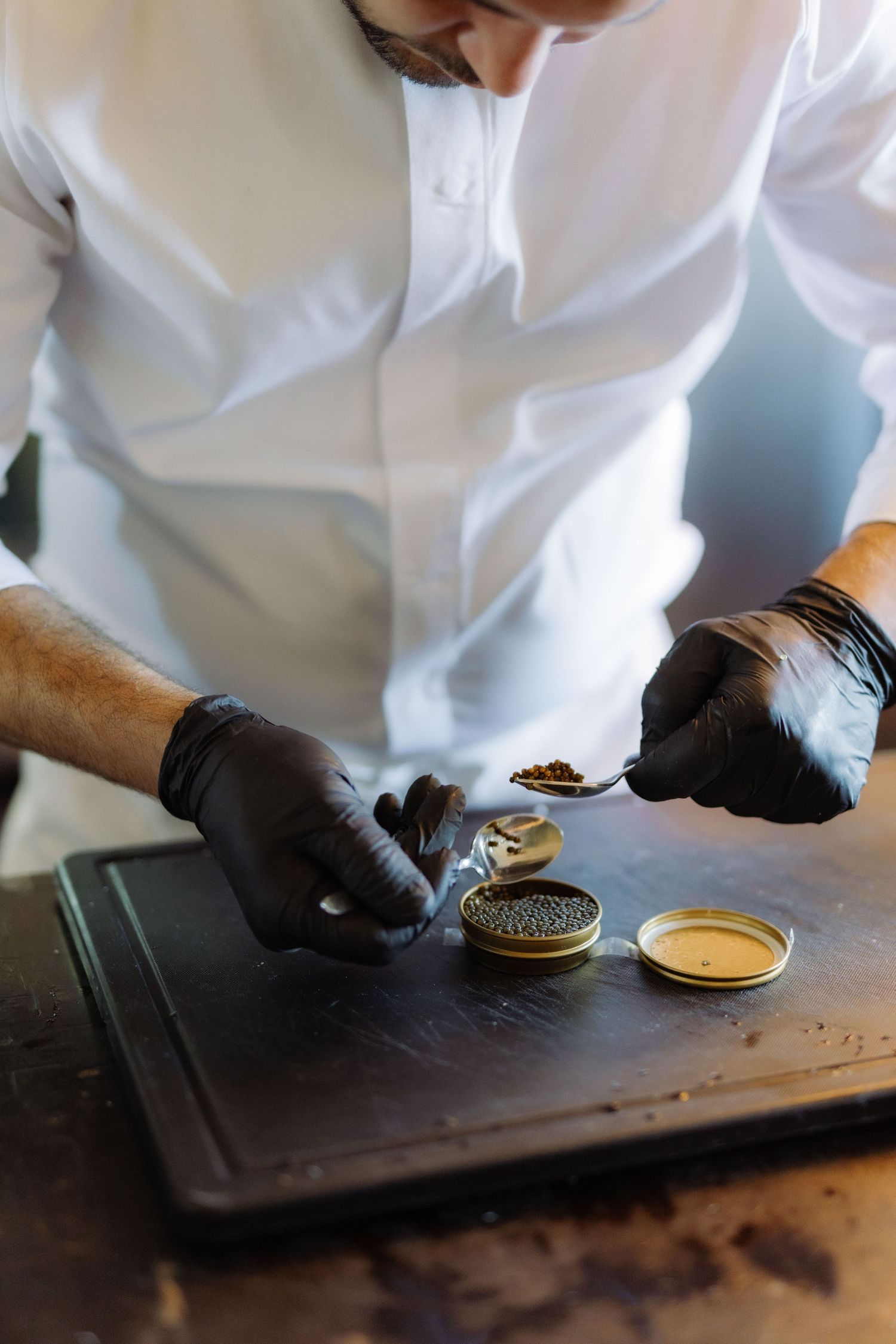 a chef prepares a starter of caviar for guests