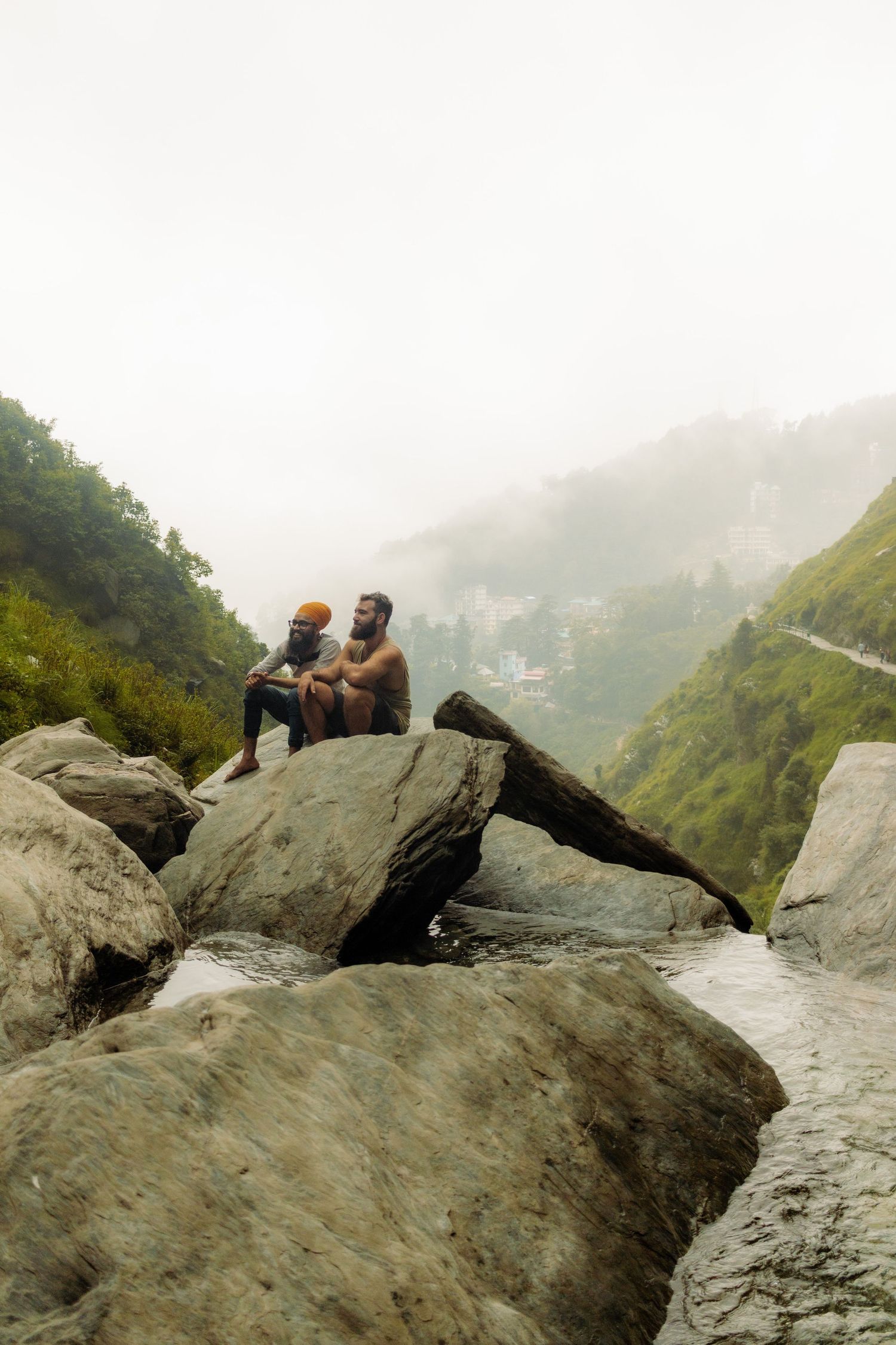 Two Sikh men on top of a waterfall in Dharamsala, India