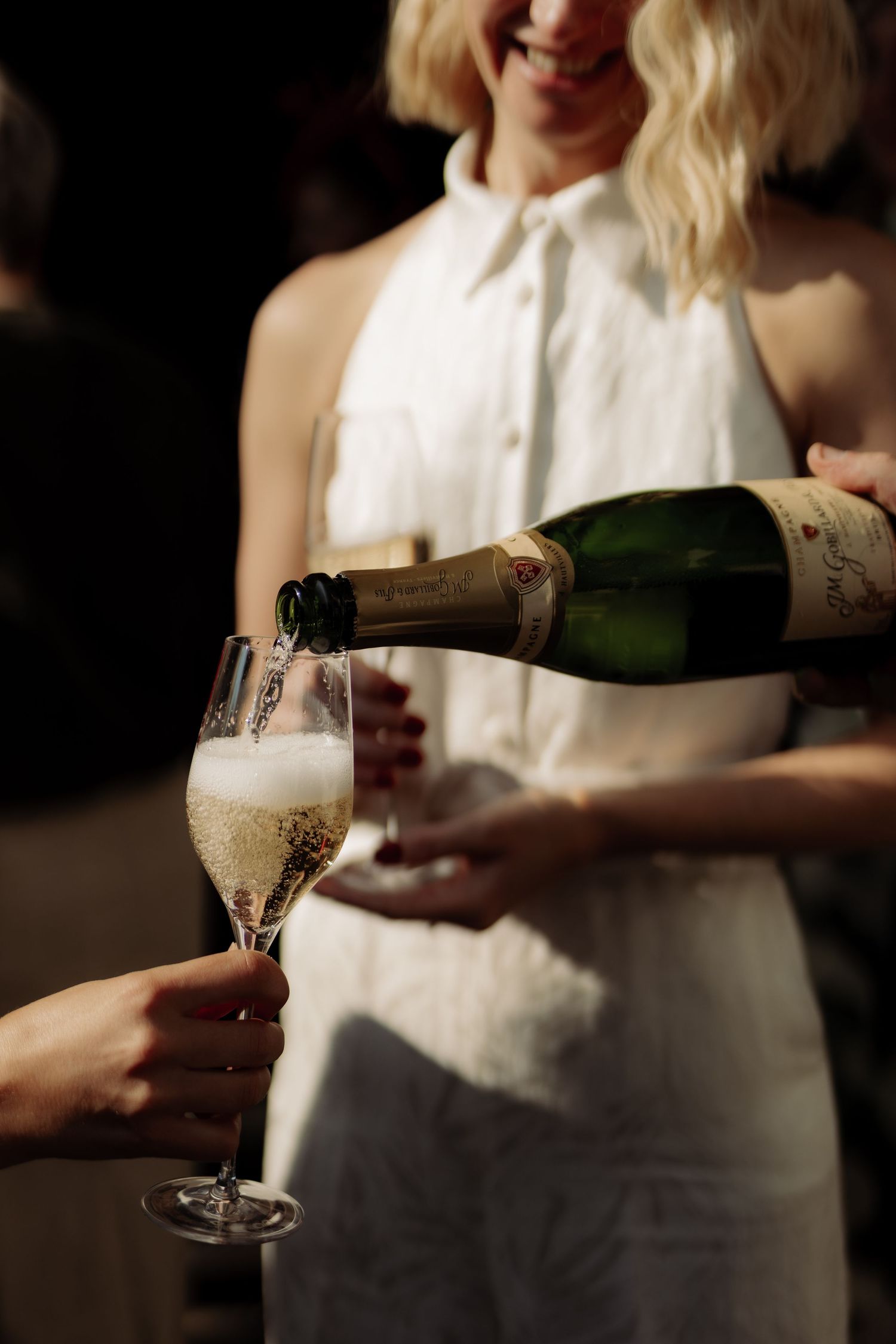 A waiter is refilling someone's champagne