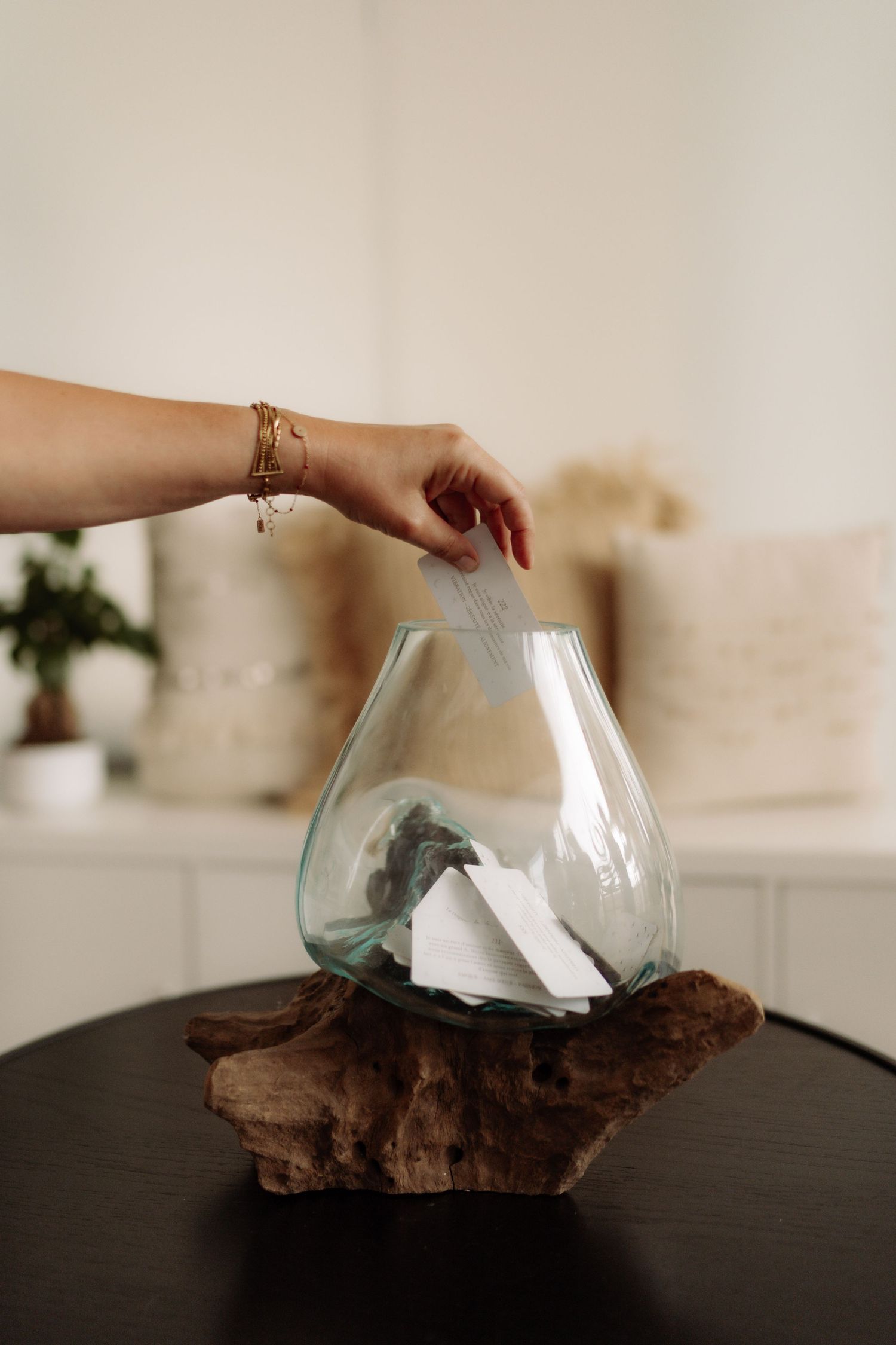 A woman is about to take a piece of paper from a bowl