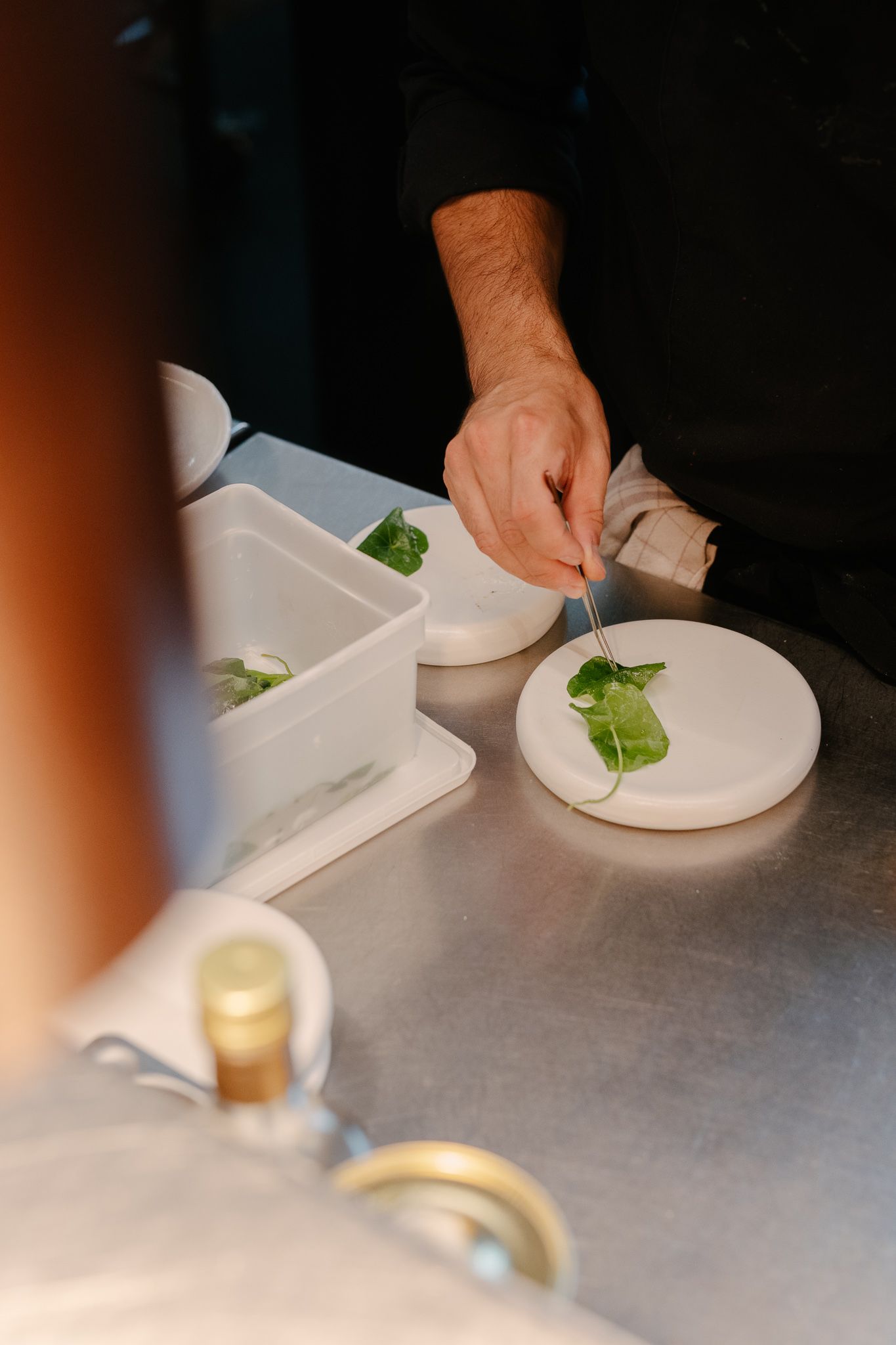 A cook plating a starter at a gastronomic restaurant