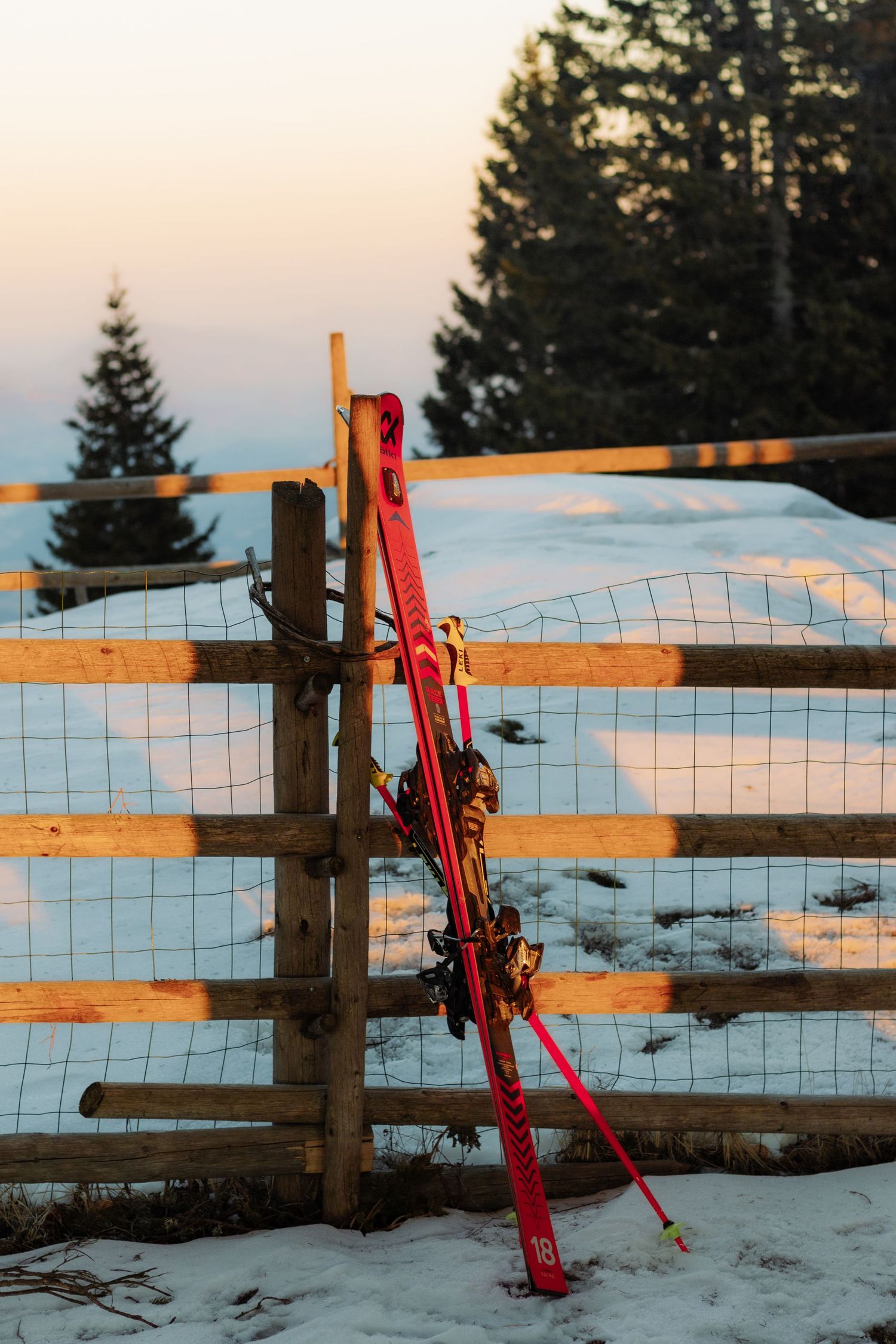 a pair of skis in front of a sunset in the mountains in Slovenia
