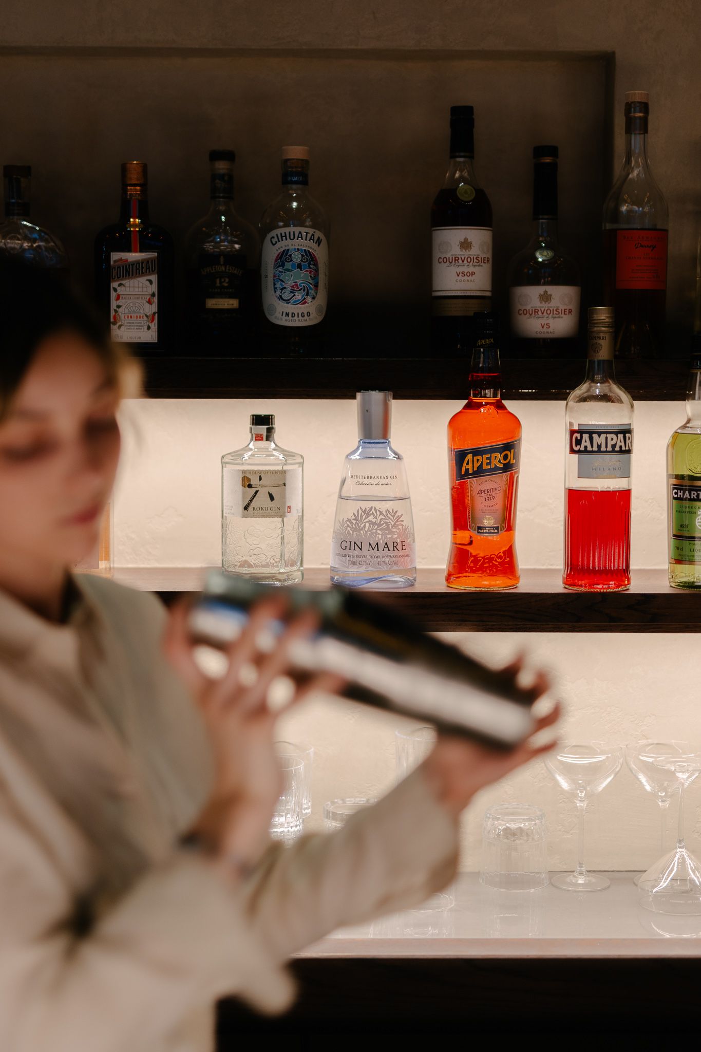 A barmaid shakes a drink