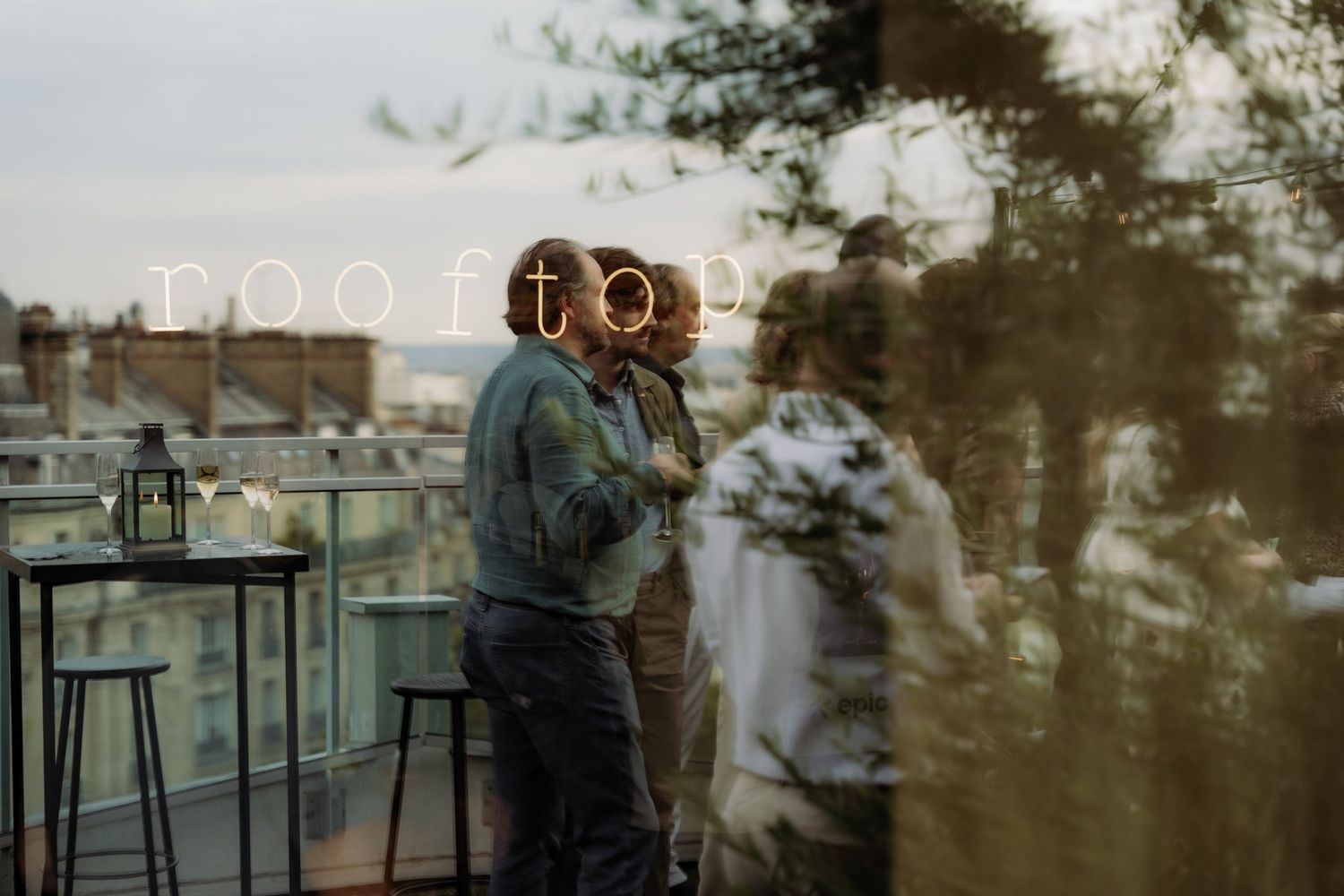 Guest can be scene in the reflection of a window on a rooftop in Paris