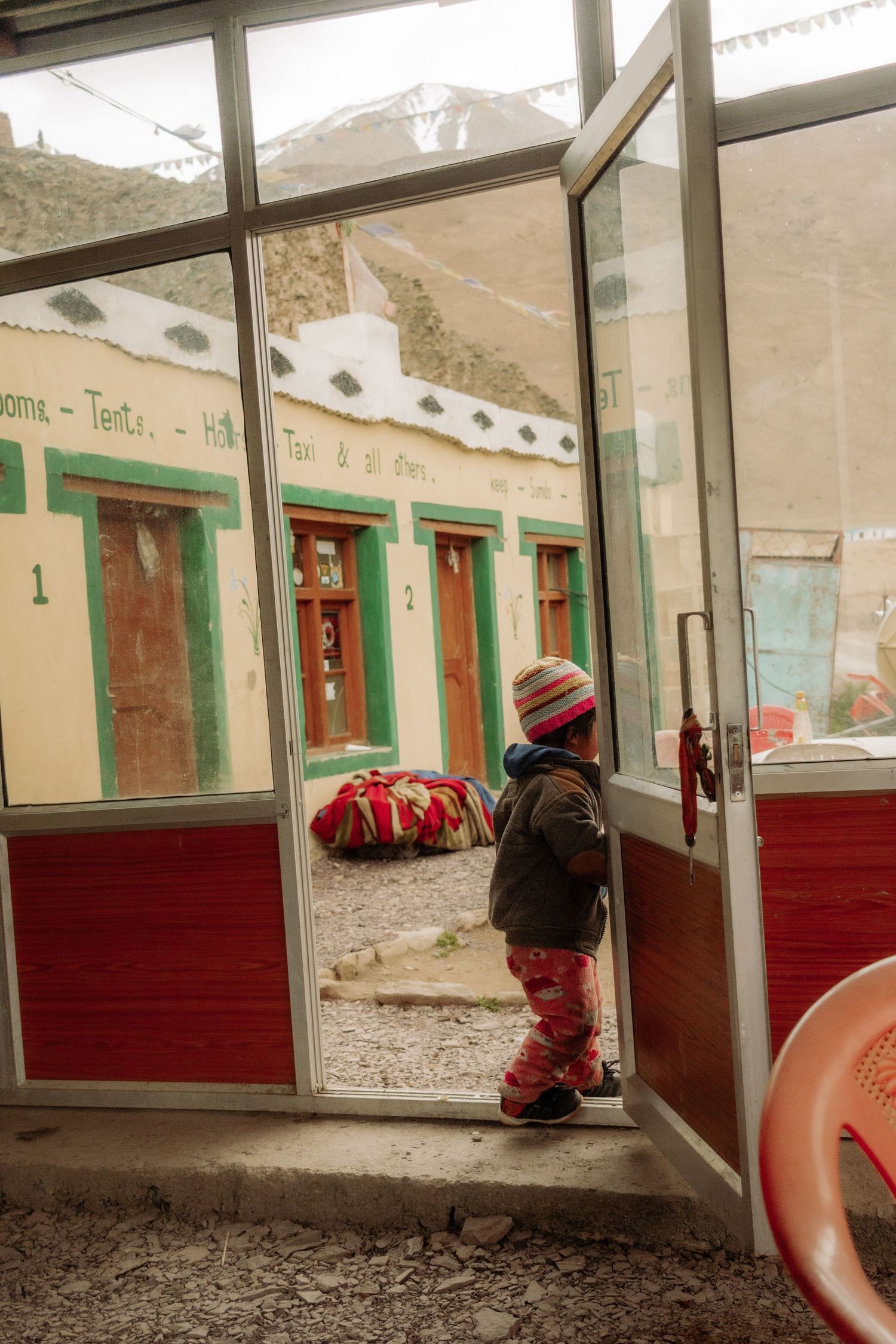 A kid outside of a coffee shop in the mountains