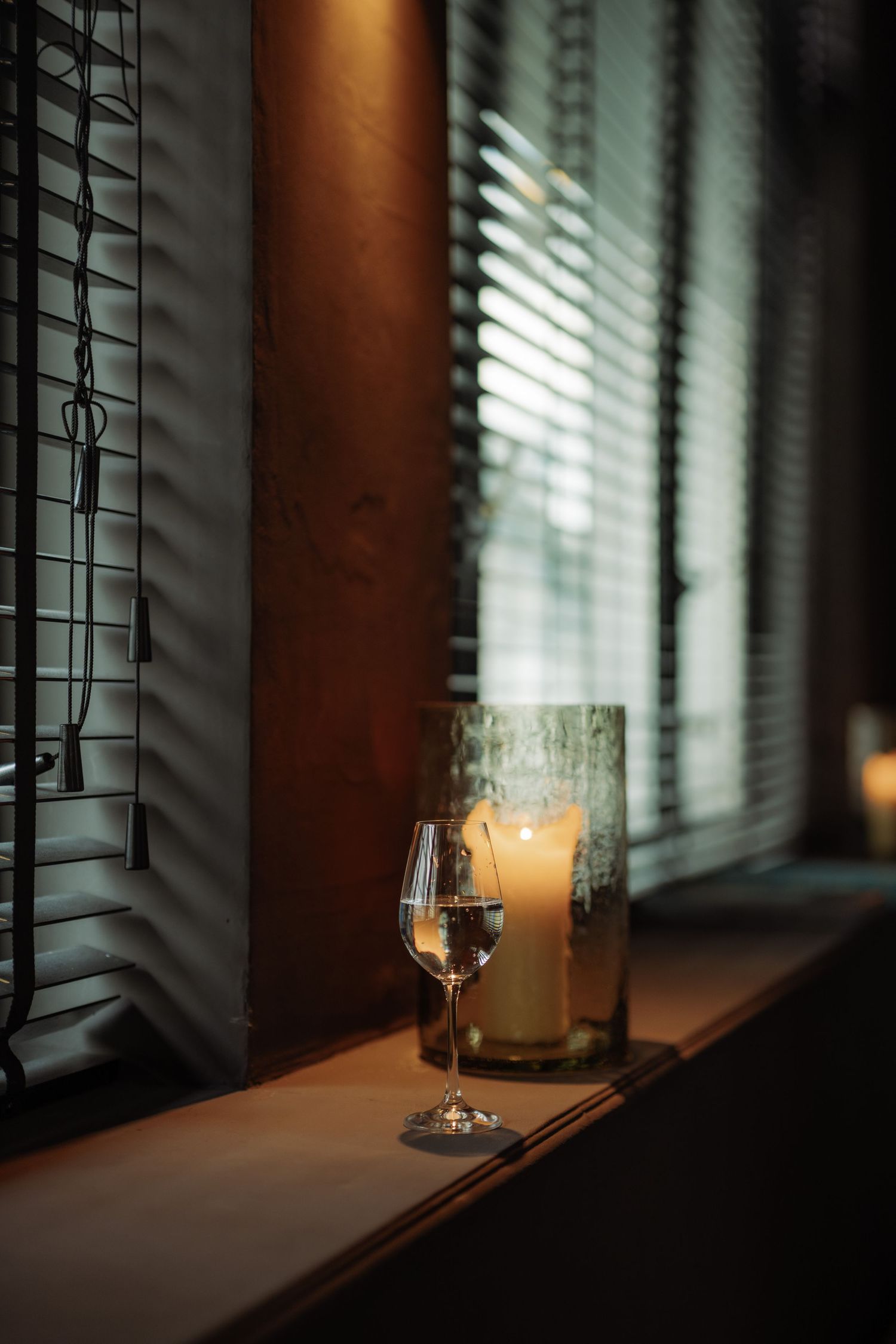 A glass of wine on the side of a window