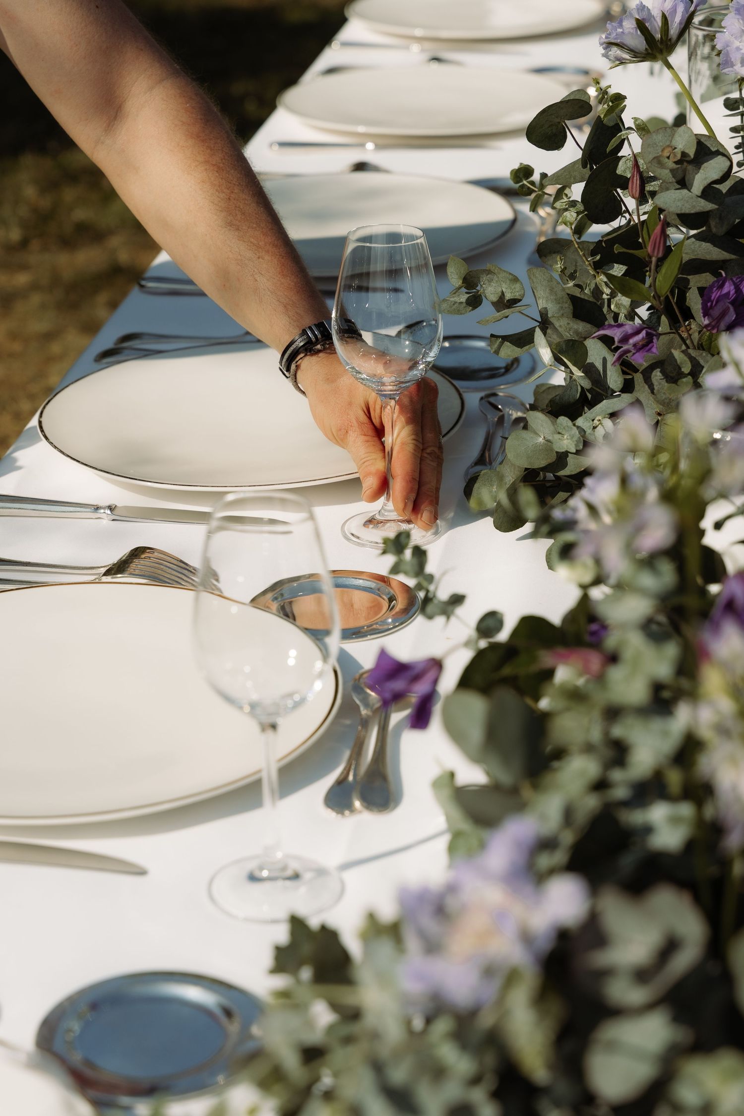 A man puts a glass on a table in a scenic place